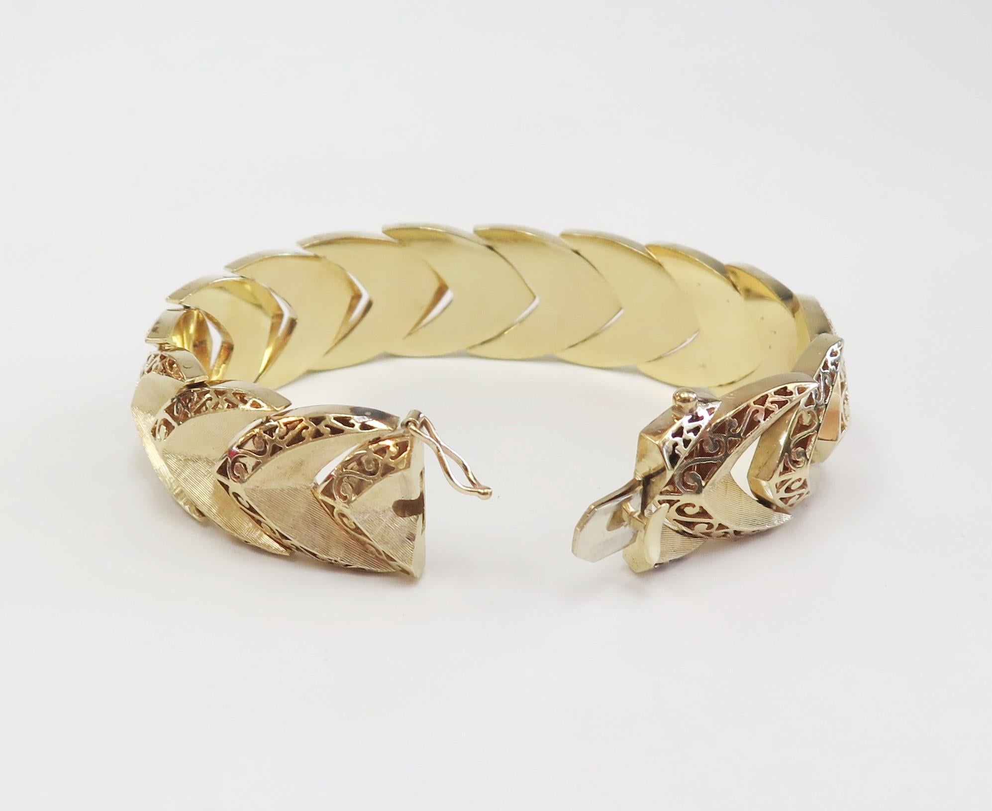 This beautiful 14 karat yellow gold bracelet has a florentine finish chevron shape, and a shiny polished scroll work design on each link. 
Width: 3/4