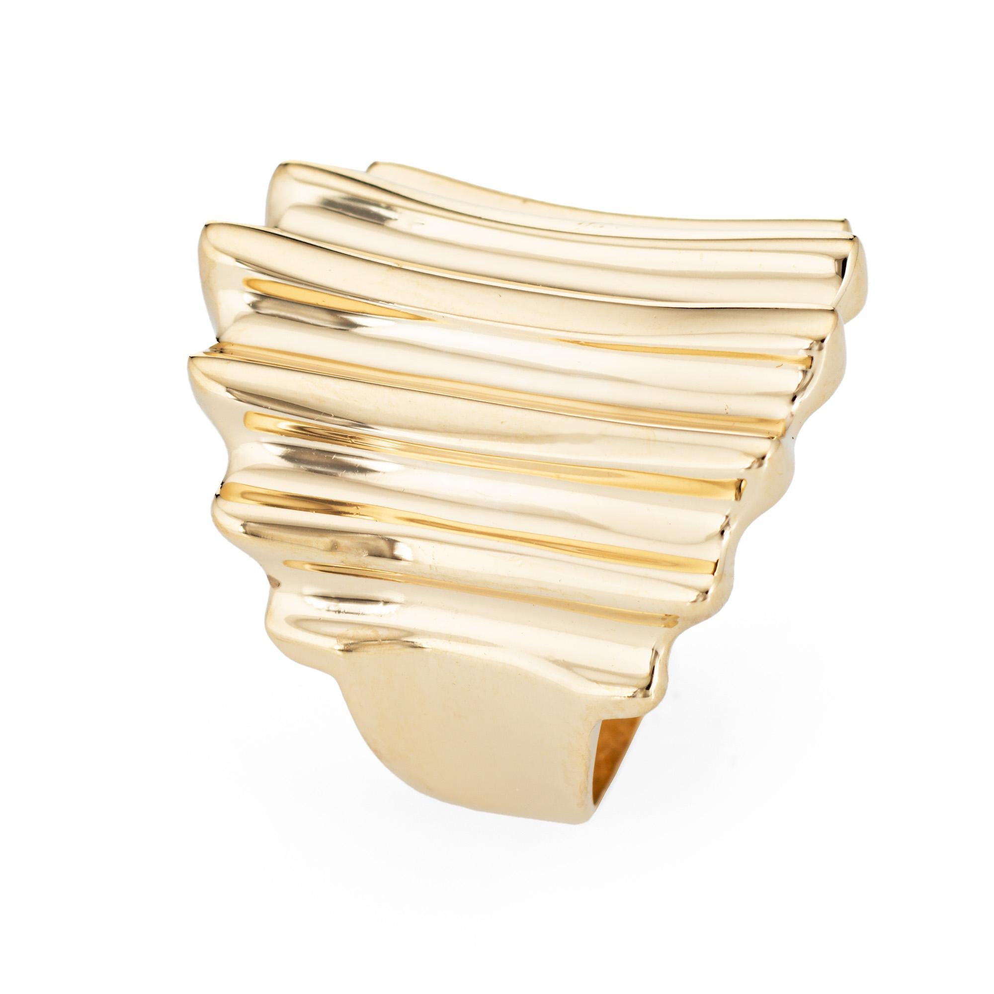 Stylish vintage sculpted cocktail ring (circa 1980s to 1990s) crafted in 14 karat yellow gold. 

The distinct & stylish ring features a concave ridged design that makes a bold statement on the hand. The low rise ring (4.5mm - 0.17 inches) sits