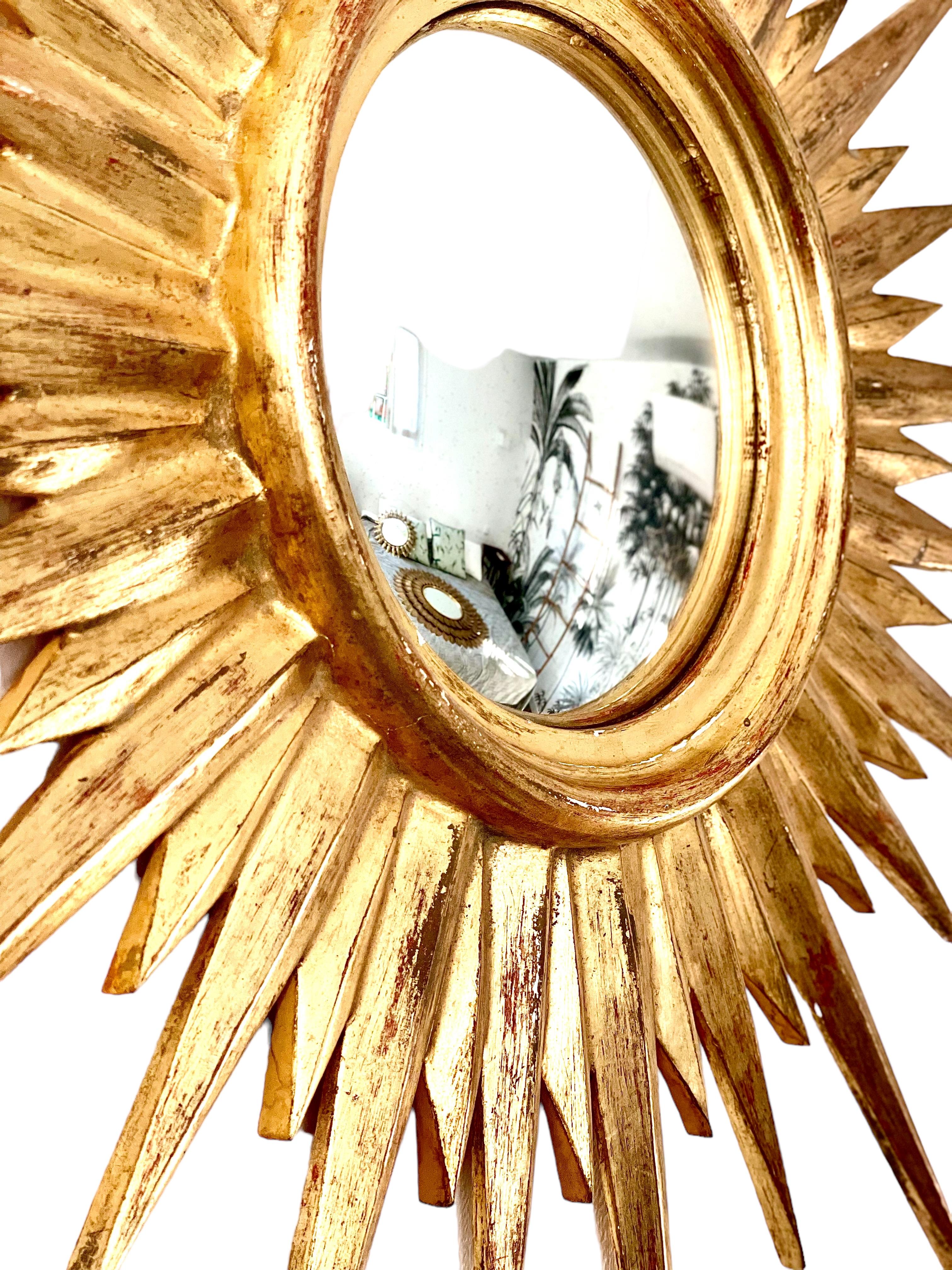 A wide and exquisite French sunburst convex mirror in golden stucco. 
In great condition.
