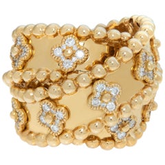 Wide crossover ring w/ "Alhambra" style design diamond stations in yellow gold