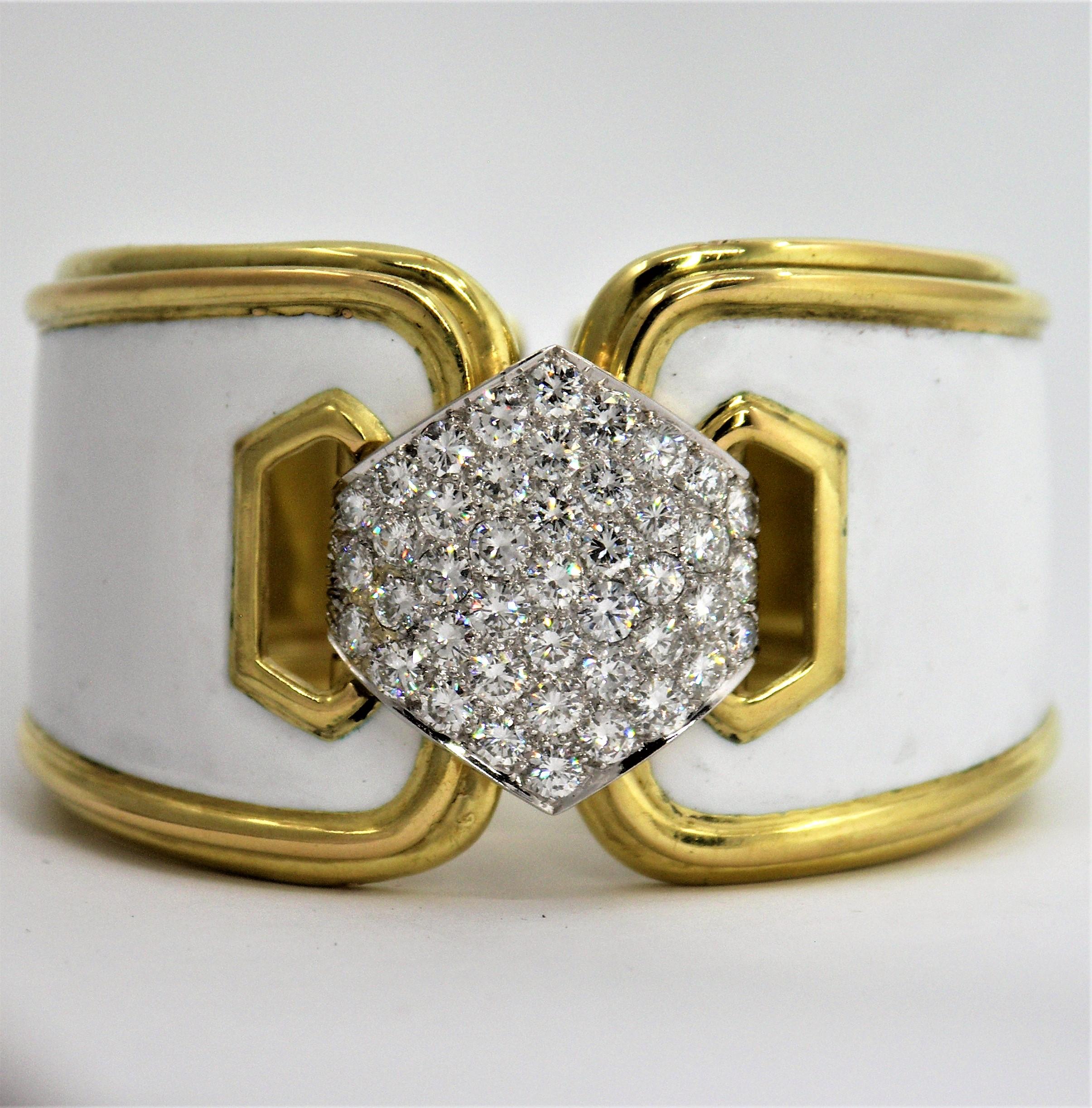 A ladies 18 karat yellow gold hinged cuff bracelet, centered around a hexagonal platinum plate with pave set diamonds weighing a total of approximately 6.5 carats of overall E/F color and VVS2/VS1 clarity.  The edges of the bracelet feature a tiered