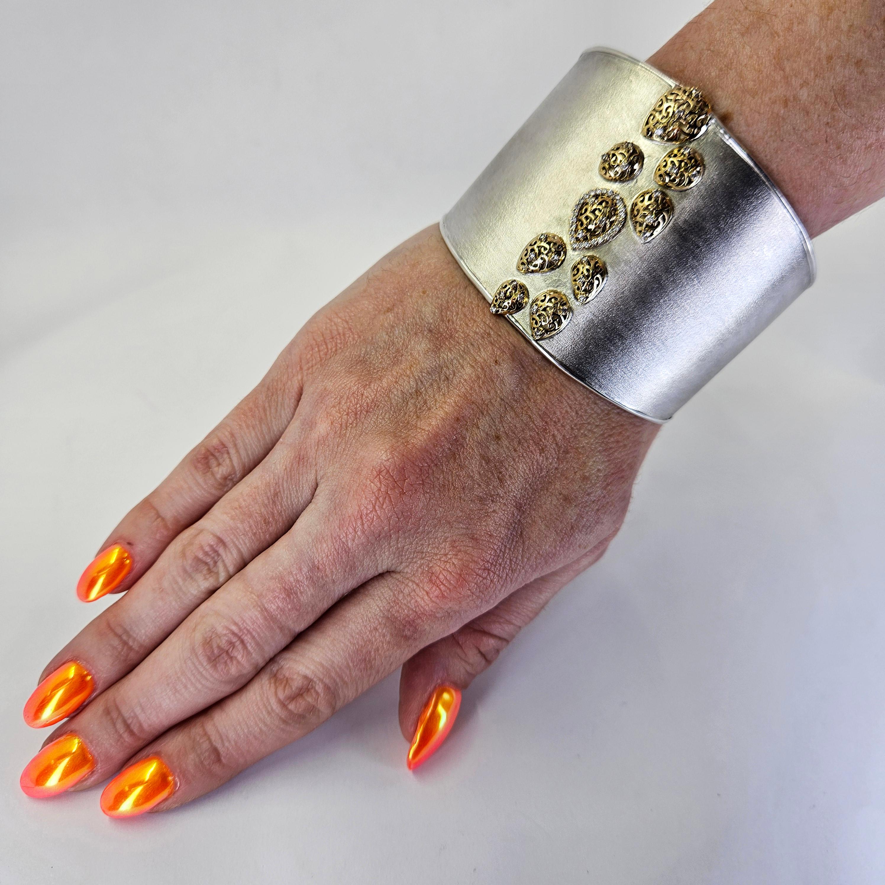 Bracelet à large manchette en argent sterling et or jaune 14 carats avec motifs de volutes en forme de poire et centre à texture brossée. 53 diamants ronds de taille Brilliante de pureté SI et de couleur H totalisant 0,27 carats. Ajustement de la