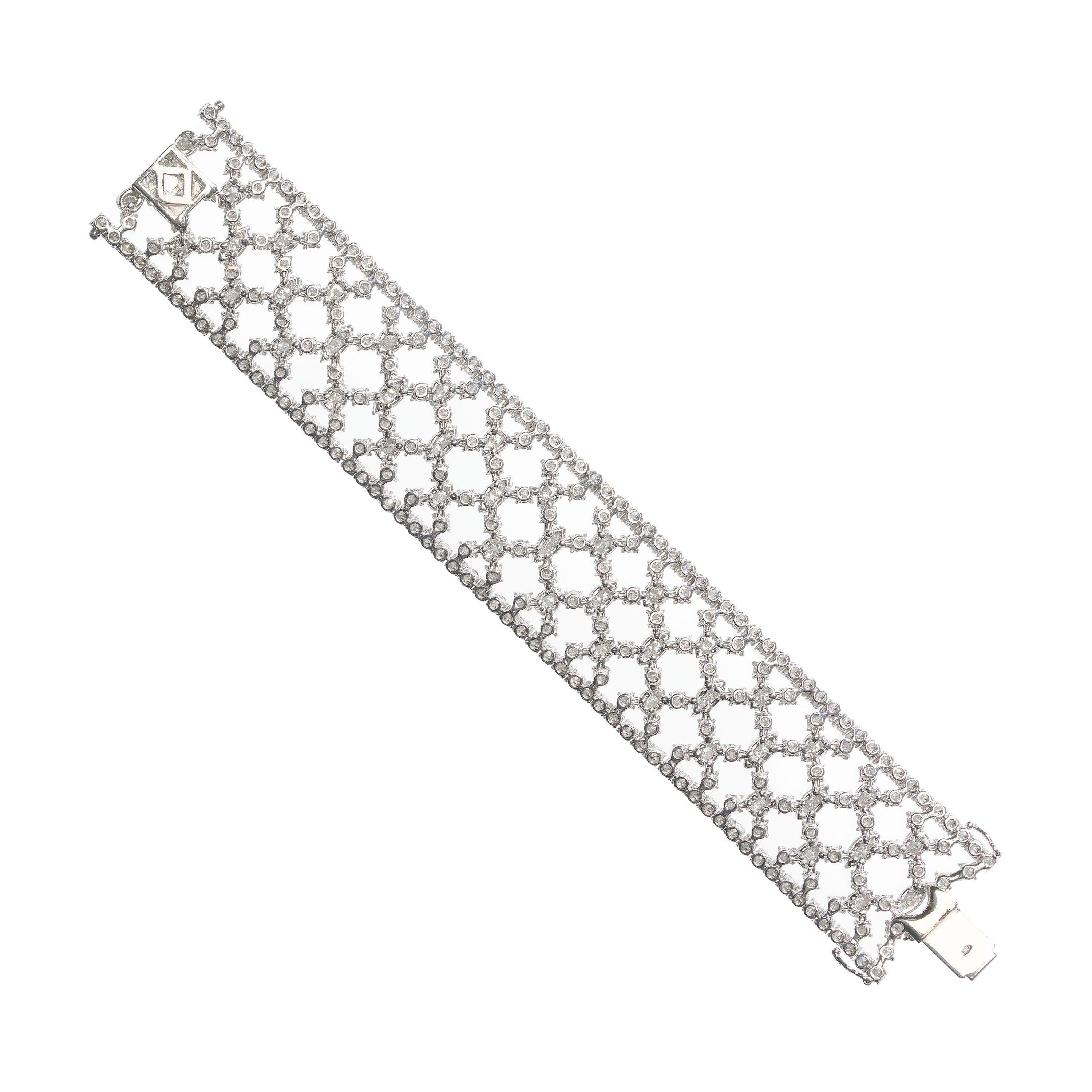 A modern wide, diamond and white gold bracelet, set with round brilliant-cut diamonds, in four claw settings, in an articulating, cross hatch, trellis like pattern, with a diamond set border, mounted in 18ct white gold, with a box and tongue clasp,
