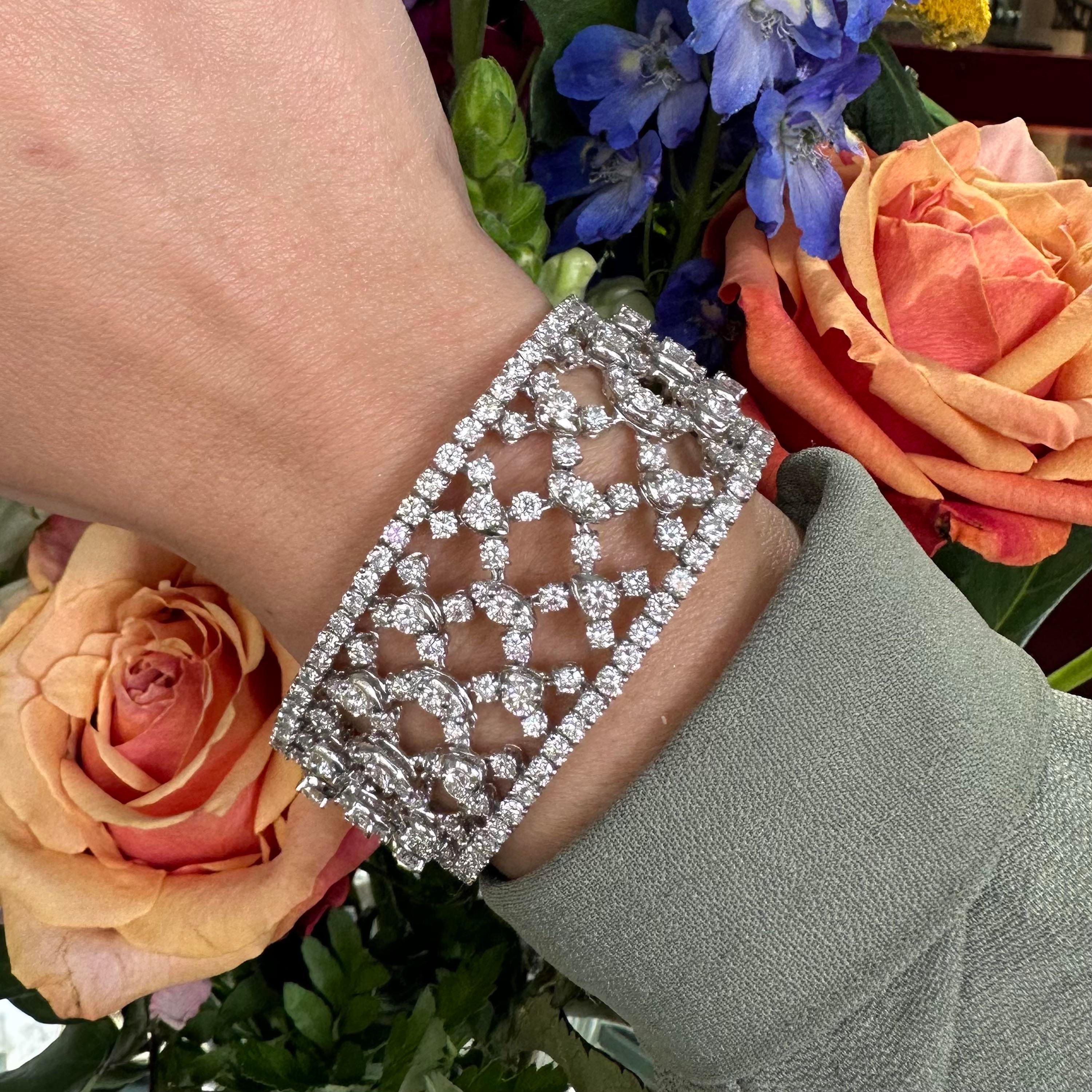 A modern wide, diamond and white gold bracelet, set with round brilliant-cut diamonds, in four claw settings, in an articulating, cross hatch, trellis like pattern, with a diamond set border, mounted in 18ct white gold, with a box and tongue clasp,