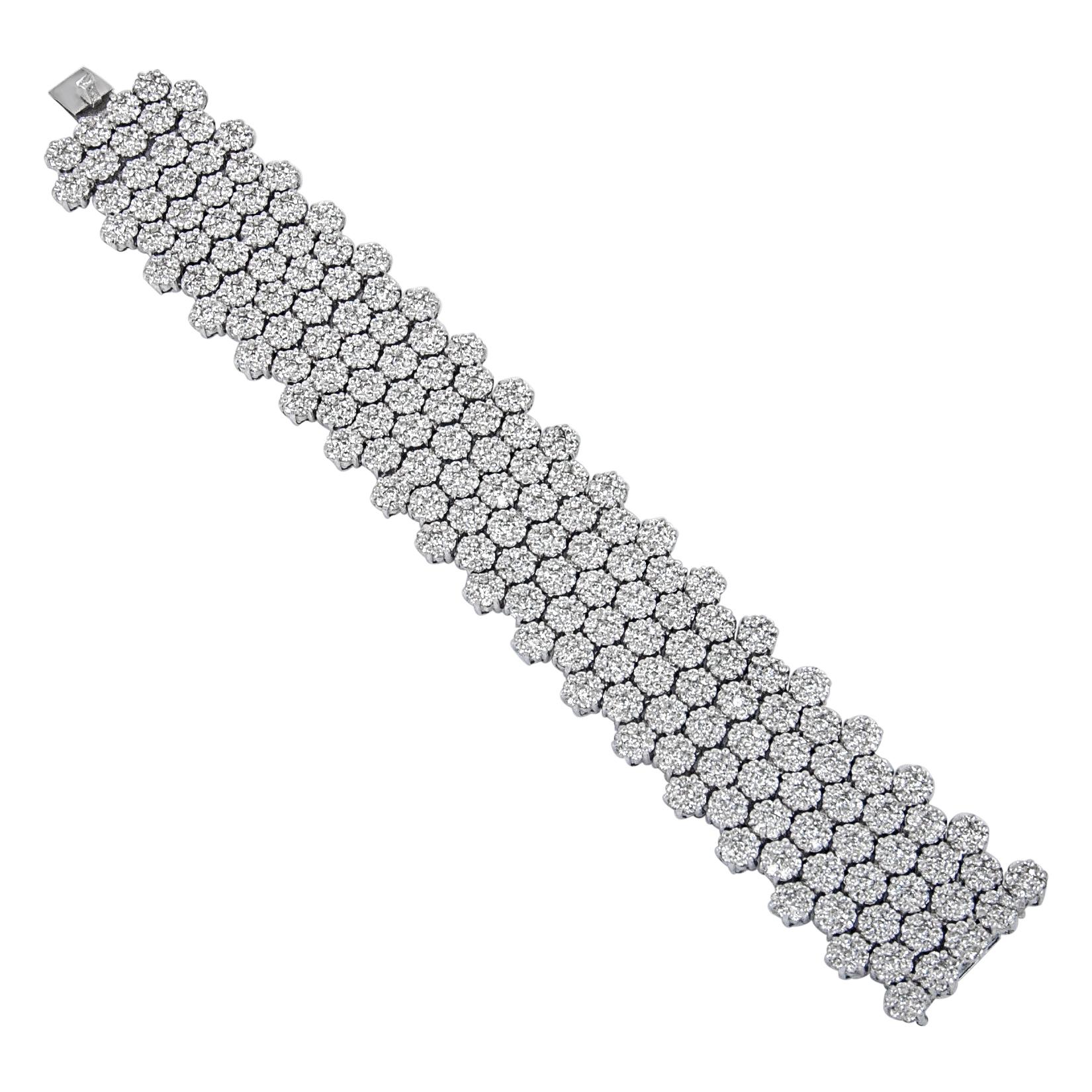 An impressive wide bracelet, handcrafted in 18 karat white gold with 162 ensembles of round shape cluster diamonds, each cluster has 7 diamonds totaling 1134 diamonds in all with total weight of 23.12 carats of round diamonds G-H color VS1 clarity.