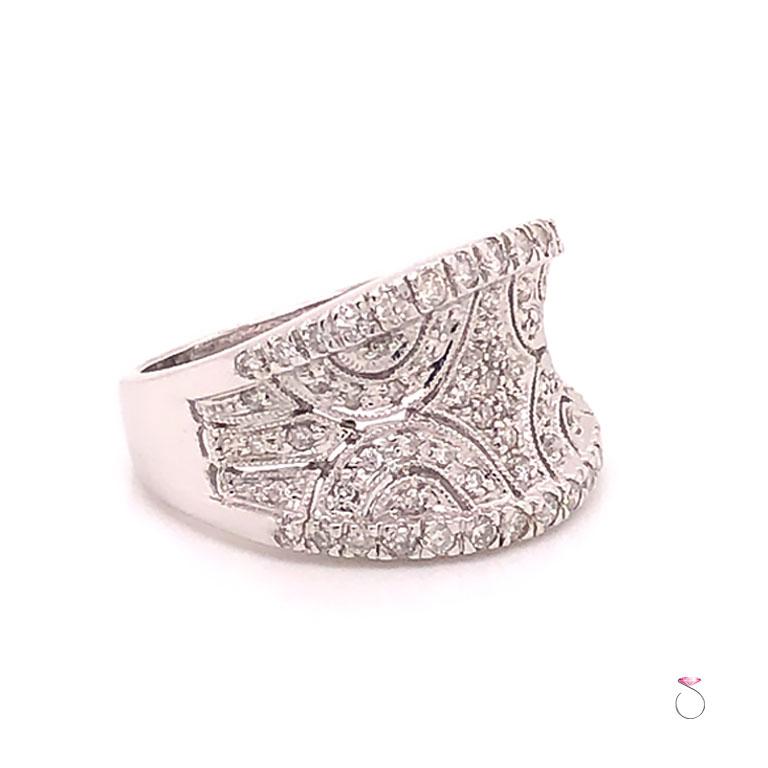 Beautiful diamond wide saddle ring in 14K white gold. This ring is beautifully designed and pave' set with 73 round brilliant cut diamonds. The ring is a saddle concave style wide band with filigree open work set with diamonds. The total weight of