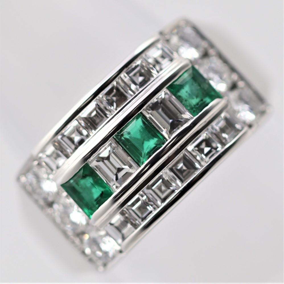 A large yet extremely comfortable platinum band featuring top quality diamonds and emeralds. There are 3 gem emeralds with a vivid grass green color weighing a total of 0.56 carats. Adding to that are large round brilliant, baguette, and asscher-cut