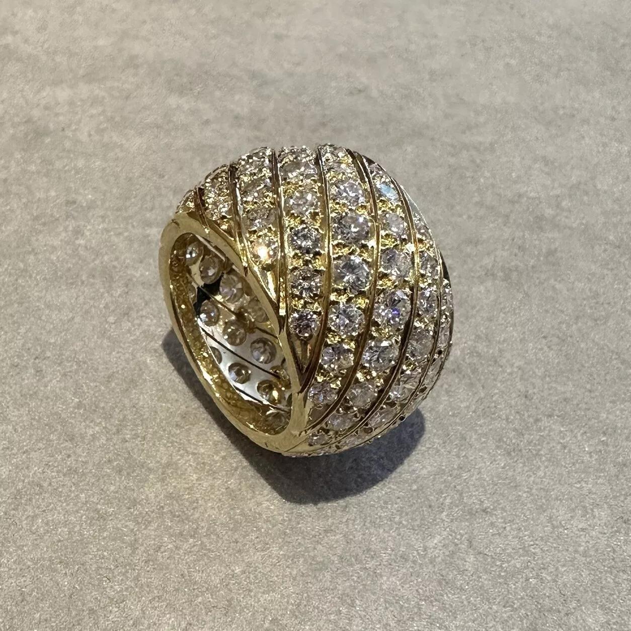 Bague d'éternité en or jaune 18k avec diamant 9.18 cttw 

Le bracelet d'éternité à large diamant présente 12 rangées diagonales de diamants ronds et brillants pesant 9,18 carats au total, le tout dans une monture de forme bombée en or jaune 18k.

Le
