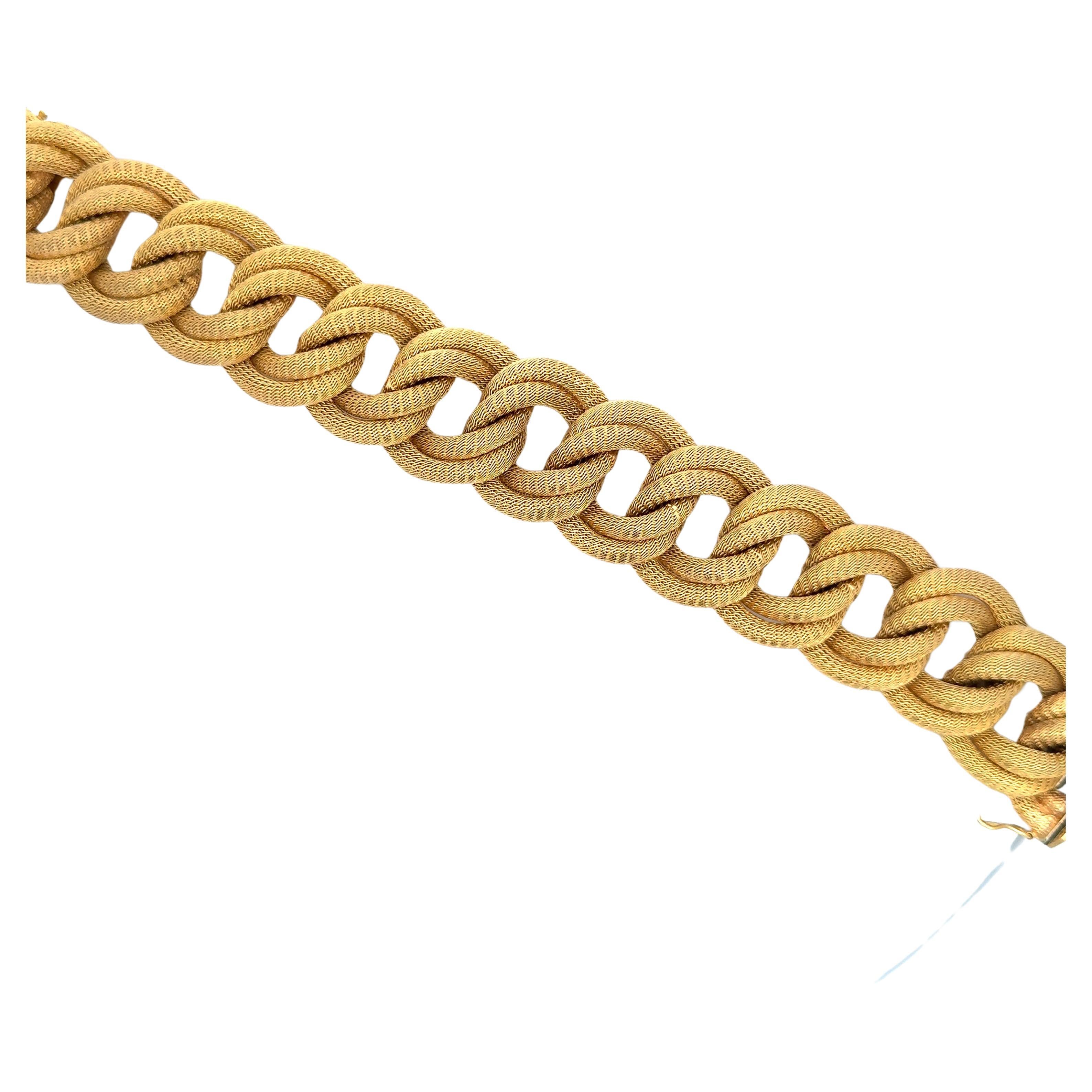 Wide woven motif bracelet featuring 14 double links weighing 104.9 grams in 18 karat yellow gold. 
Very comfortable on the wrist.