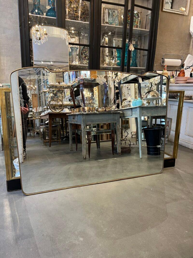 Handsome mid-century brass mirror, from Italy circa 1960s, in a beautiful horizontal design, with charming motifs etched into the mirror glass, and a beautiful wide brass profile.

The mirror glass is original and the form can easily be