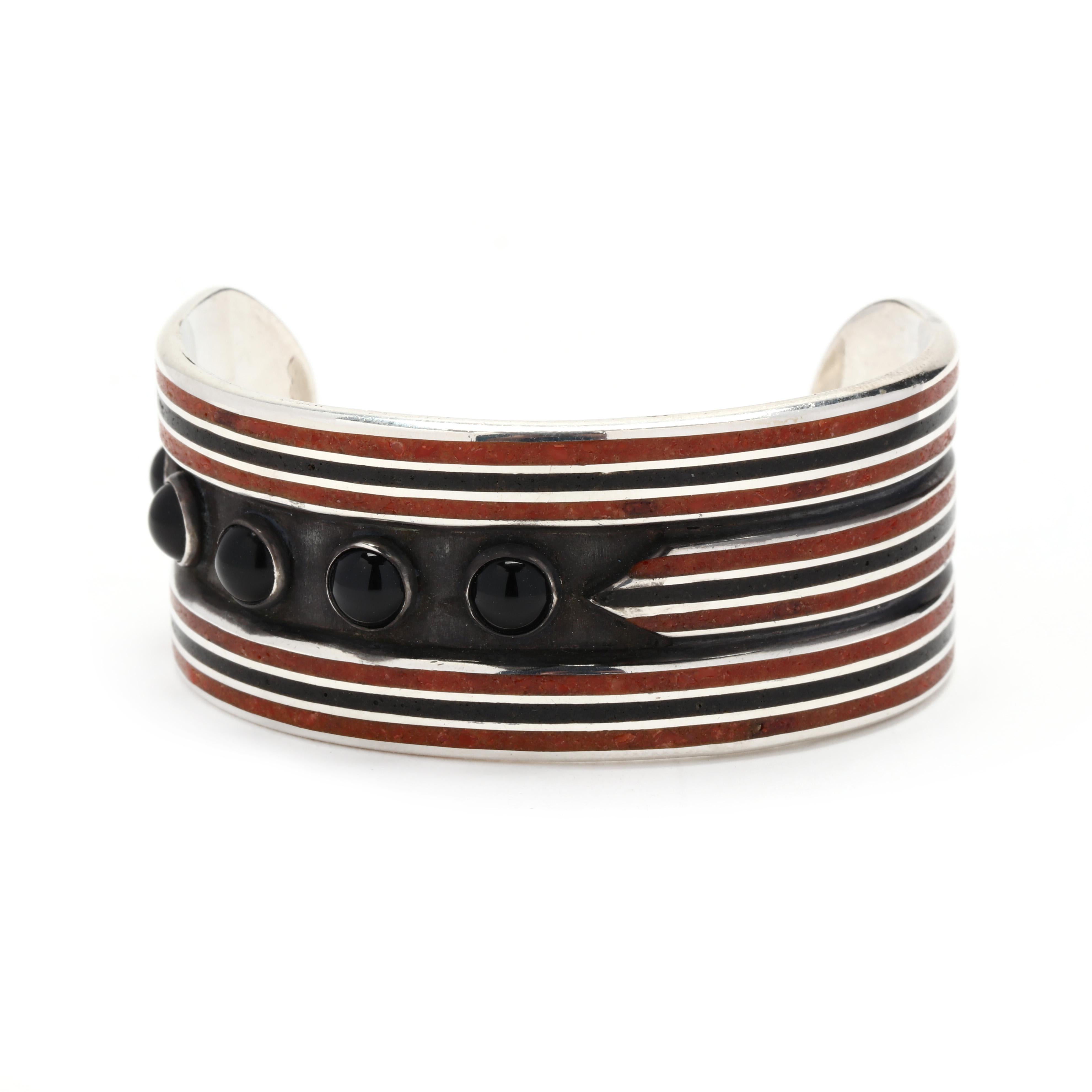 A vintage sterling silver wide geometric black onyx and enamel cuff bracelet.  This statement bracelet features a geometric design with black, brown, and silver enamel lines with offset bezel set cabochon black onyx. It is stamped Sterling.