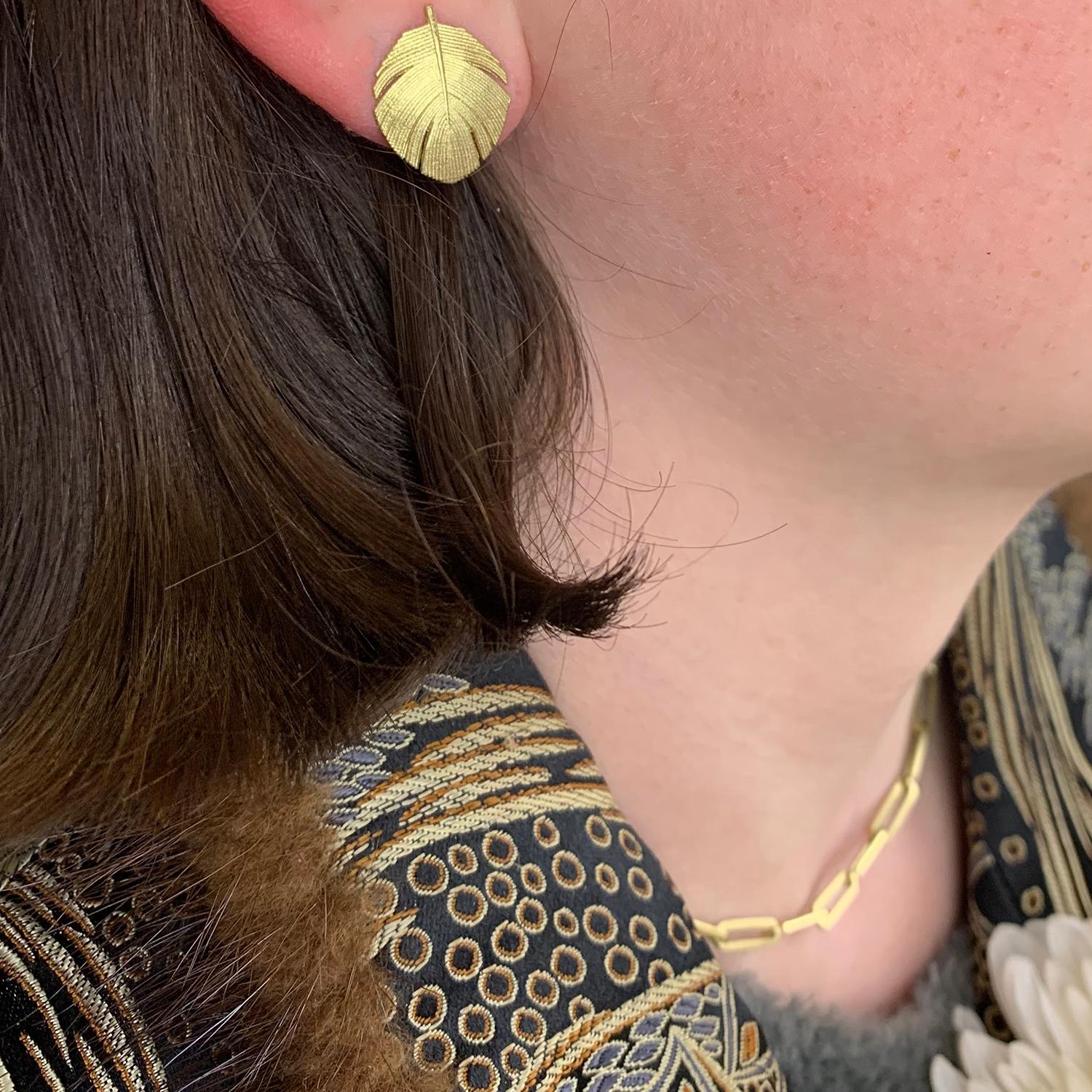 Fabulous 18k yellow gold feather earrings with tube set diamond accents will glitter and glow on your ears! A smaller version of our wide gold feather earrings might be just what you're looking for. The earrings are post backed and measure 3/4
