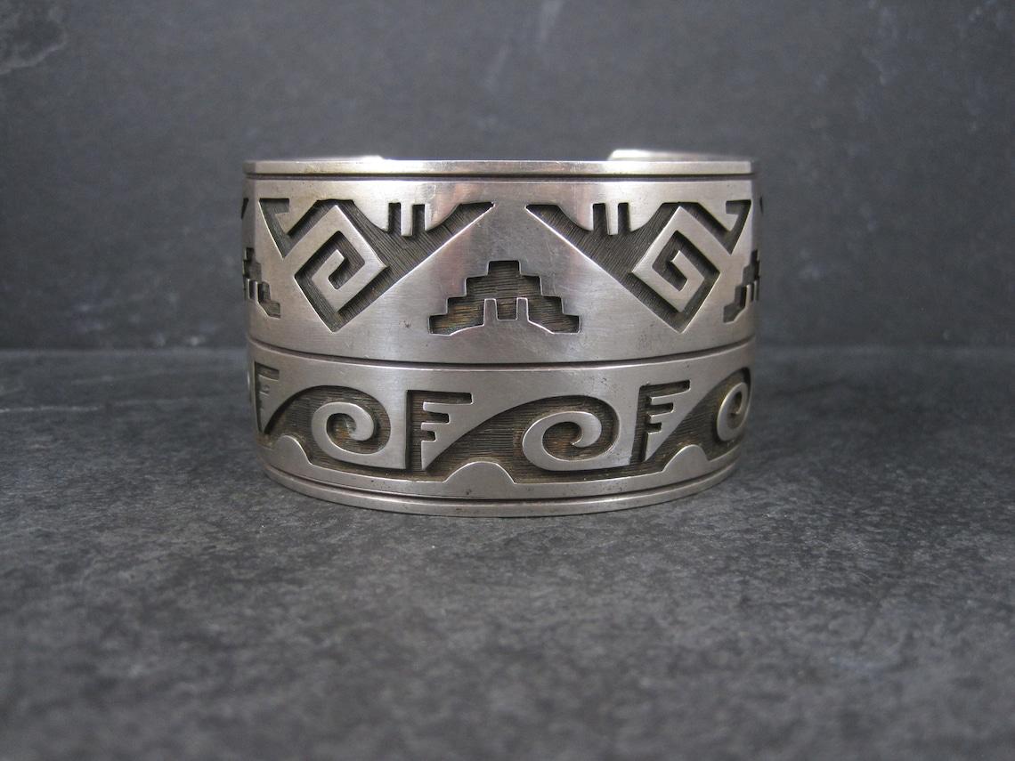 Dieses atemberaubende Manschettenarmband ist aus Sterlingsilber.

Es misst 1 9/16 Zoll breit.
Er hat einen Innenumfang von 7 Zoll, einschließlich der Lücke von 1 Zoll.

Gewicht: 91,7 Gramm

Markierungen: Sterling, ET innen Dachs Tatze

