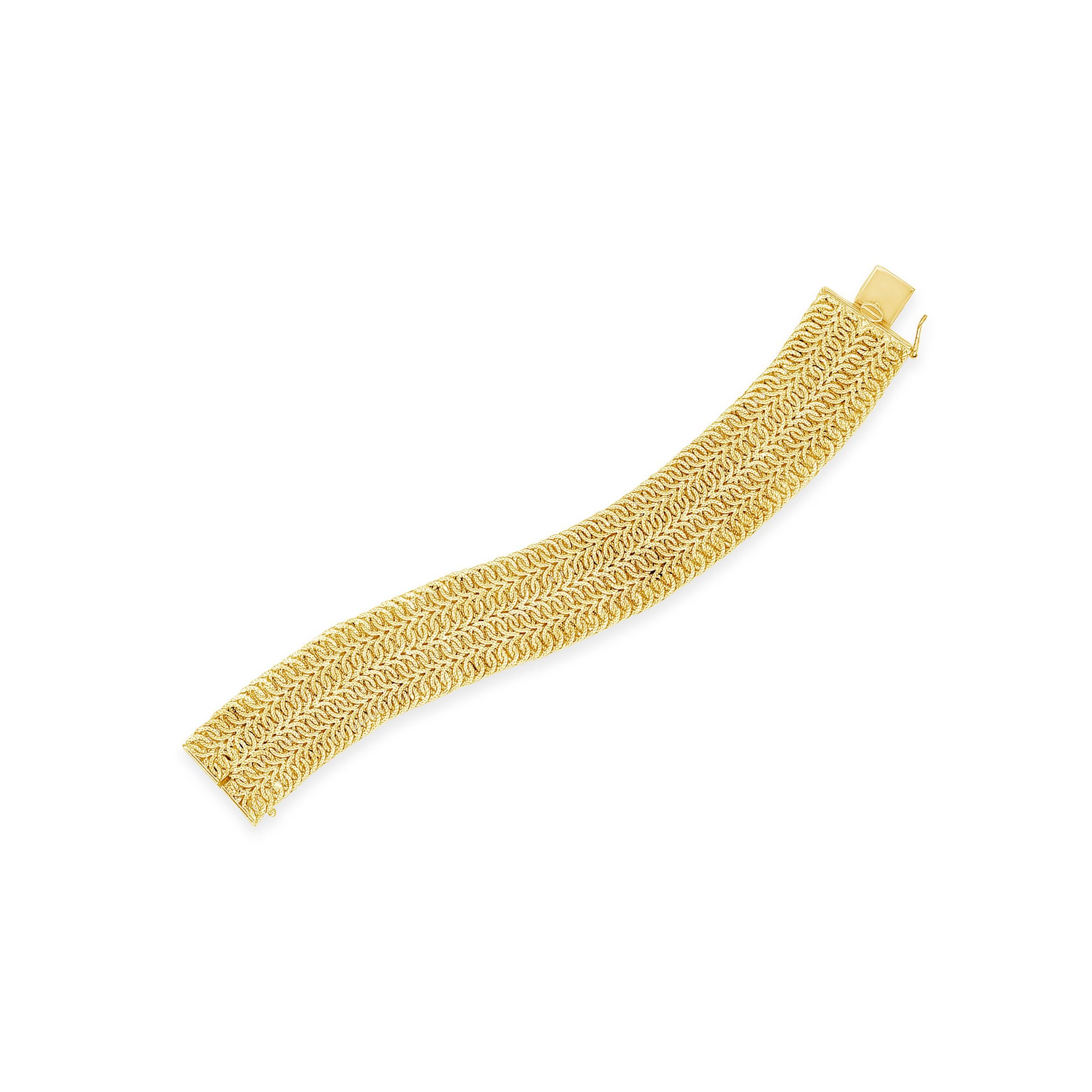 Un bracelet complexe composé de cordes entrelacées, réalisé en or jaune 18 carats par Giovanni Marchisio. Les cordes sont terminées par des motifs géométriques. Largeur : 23,5 mm ; poids total : 60,75 grammes. Longueur approximative de 7 pouces.