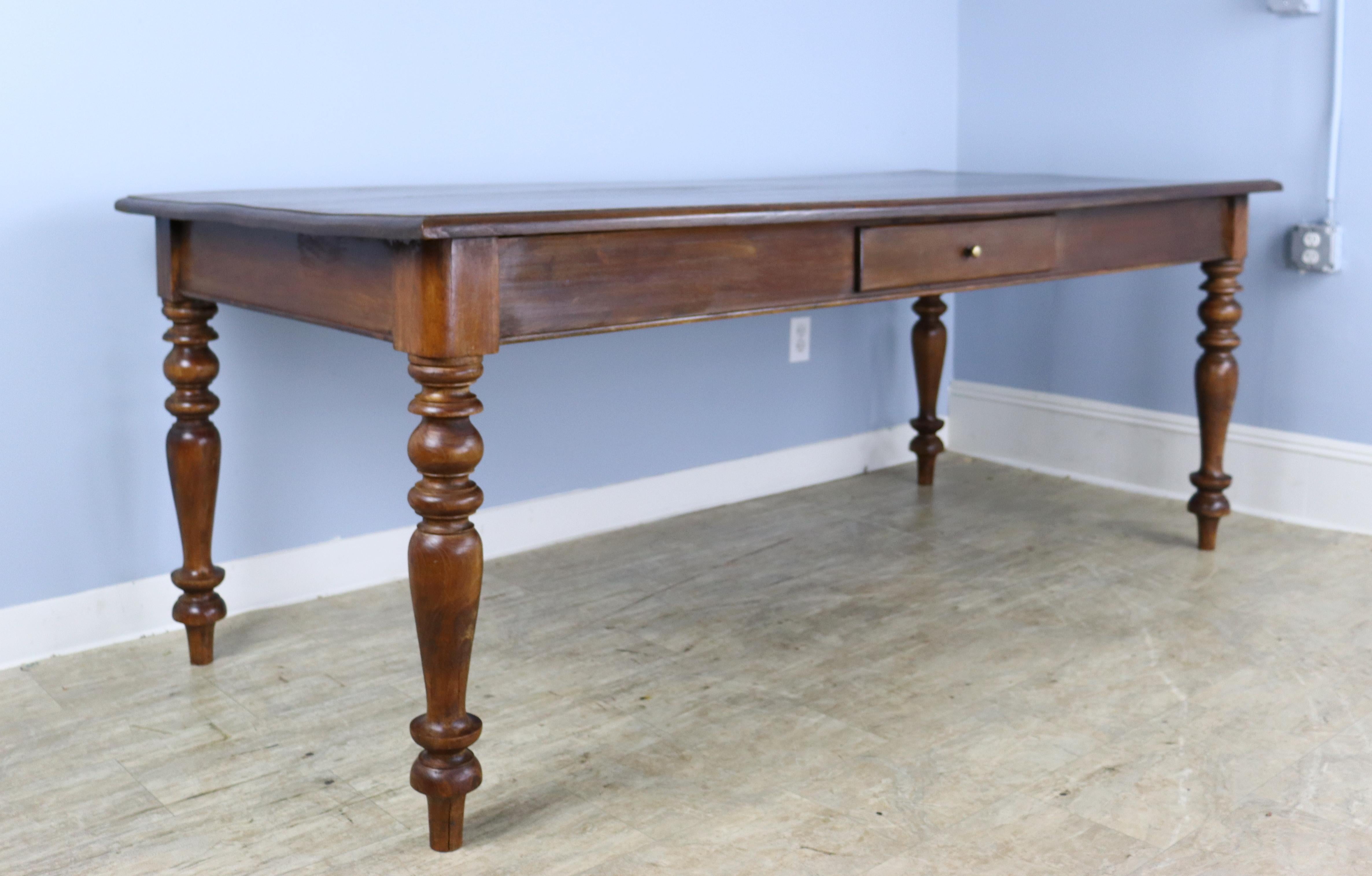 The best of both worlds. A handsome dark oak farm table with the look of an antique, but with the proportions of a modern dining table. The top and legs are in very good condition. Nice and deep to accommodate platters and chargers, the apron height