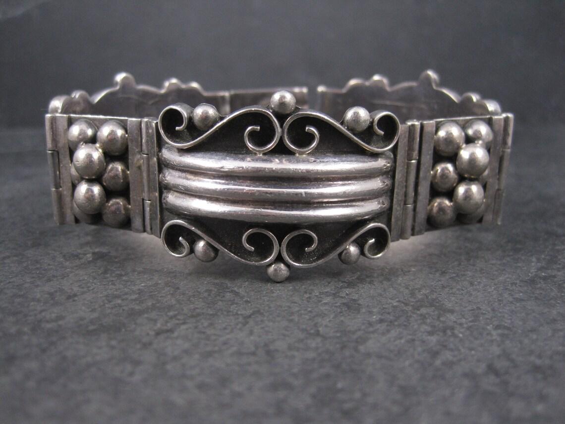 This gorgeous vintage panel bracelet is sterling silver.

At its widest point, this bracelet measures 1 1/8 inches wide and is 7.5 inches long.
The clasp is in great working order.

Weight: 63.6 grams

Marks: Mexico, 925, C-11

Condition: Excellent