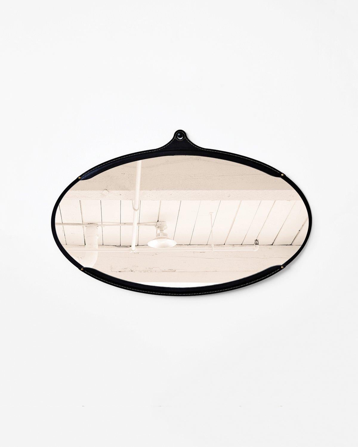 The fairmount wide oval mirror is a hand-stitched leather mirror. Each piece of leather has its own character and variations lending to the appeal of the material. The mirror sits inside the frame like a pocket and comes with an iron hand hammered