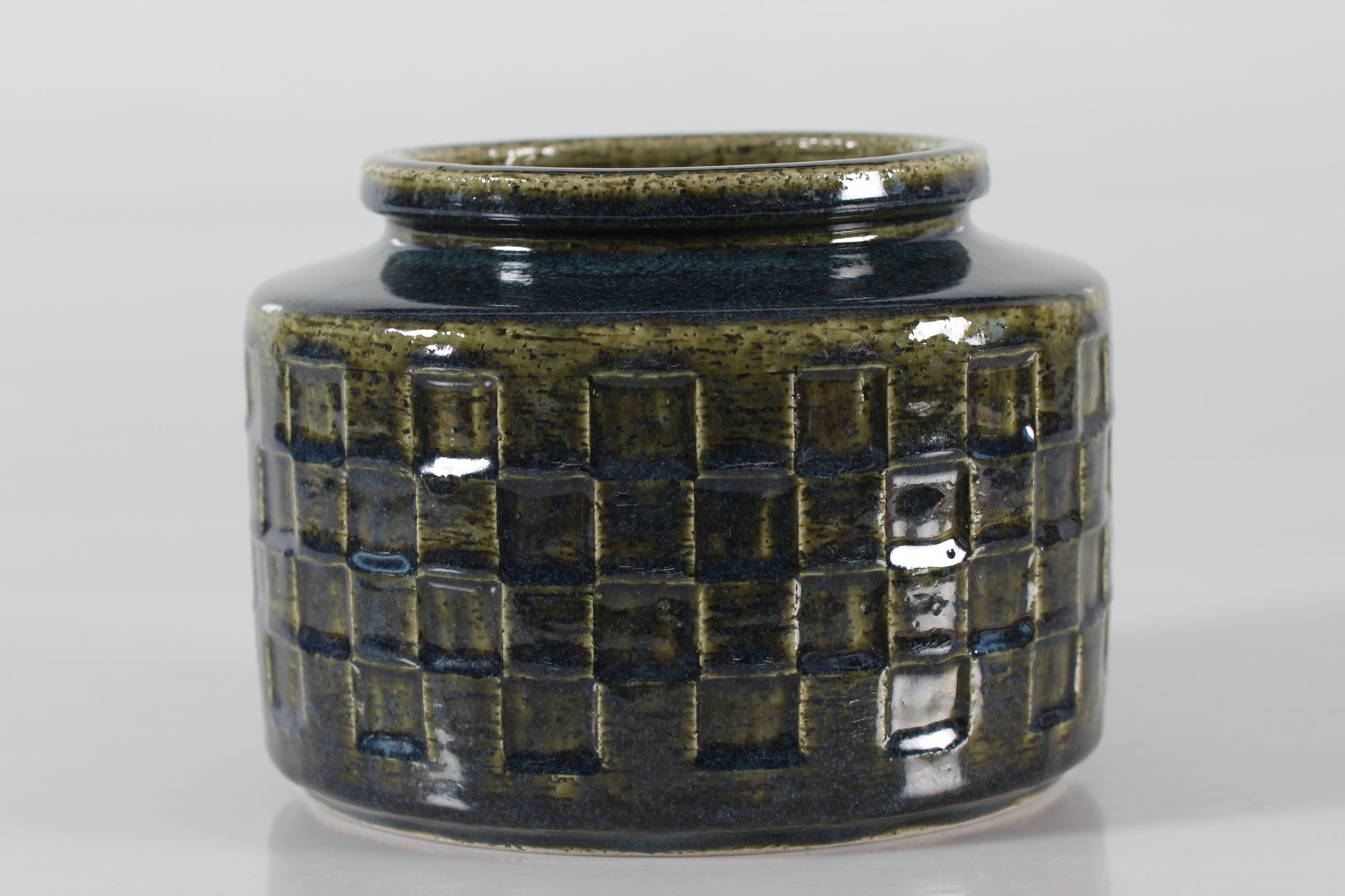 Ceramic vase by Per Linnemann-Schmidt for Palshus Denmark model no. C 19. Made in the 1960s.
It is made of chamotte stoneware clay which gives a rough and vivid surface. It has a glossy bottle green glaze with blue accents over a textured geometric
