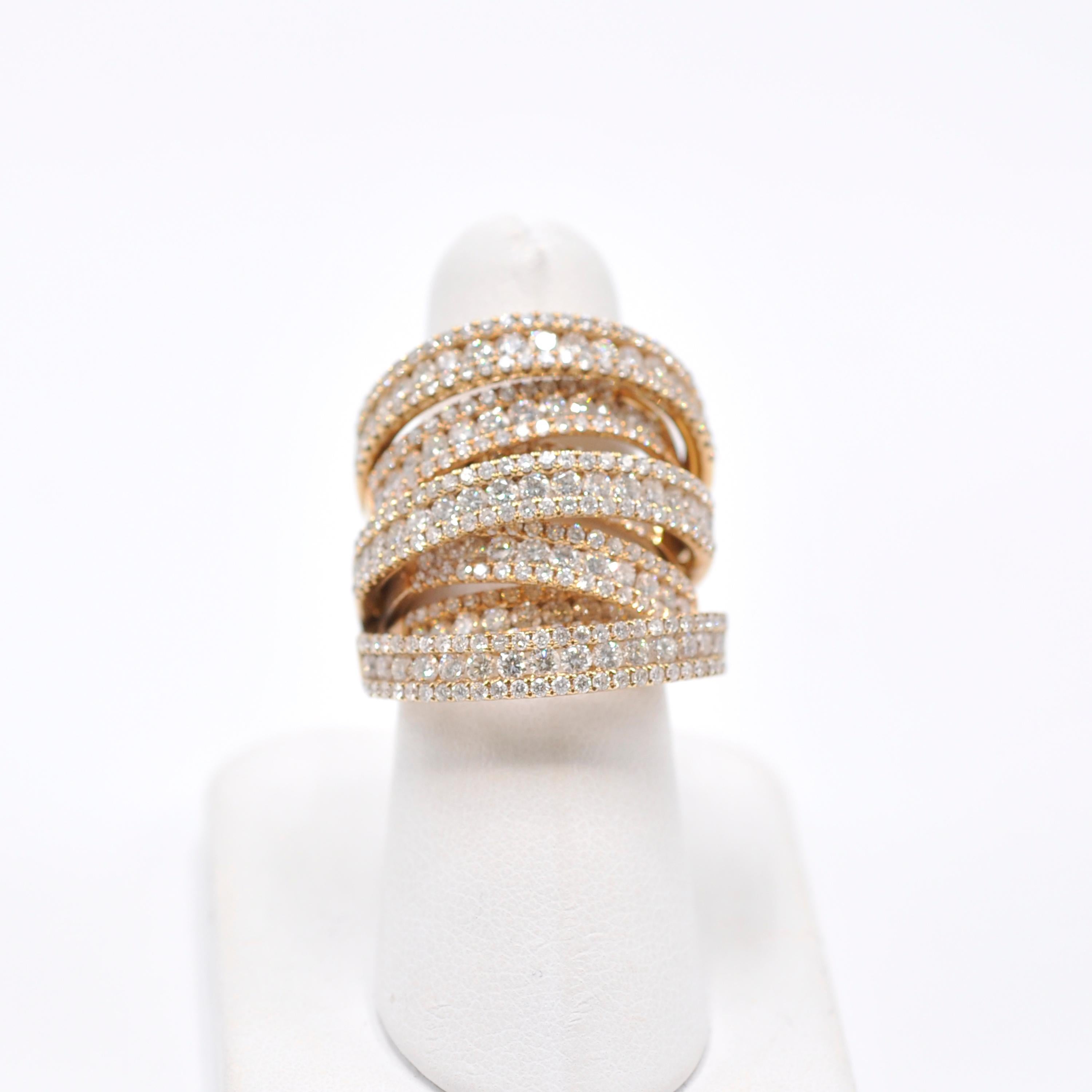 This edgy take on the diamond band overlaps seven 18 karat yellow gold bands of a total of 8 CTS of round cut diamonds. The bands taper down under the finger for comfort making this ring versatile. Wear it to dress up your favorite jeans or to spice