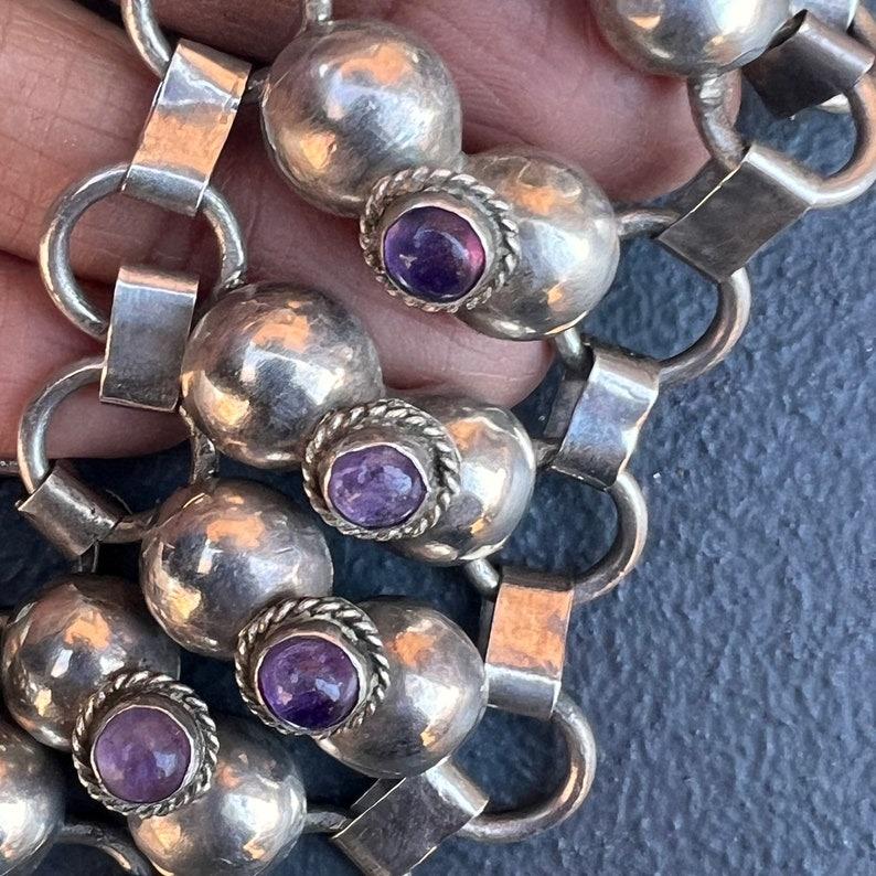 Ein auffälliges und gut verarbeitetes Armband aus mexikanischem Sterlingsilber vom Anfang bis zur Mitte des 20. Jahrhunderts mit zwölf kunstvoll miteinander verbundenen Feldern, die jeweils mit einem Amethyststein in Lünettenfassung besetzt sind.