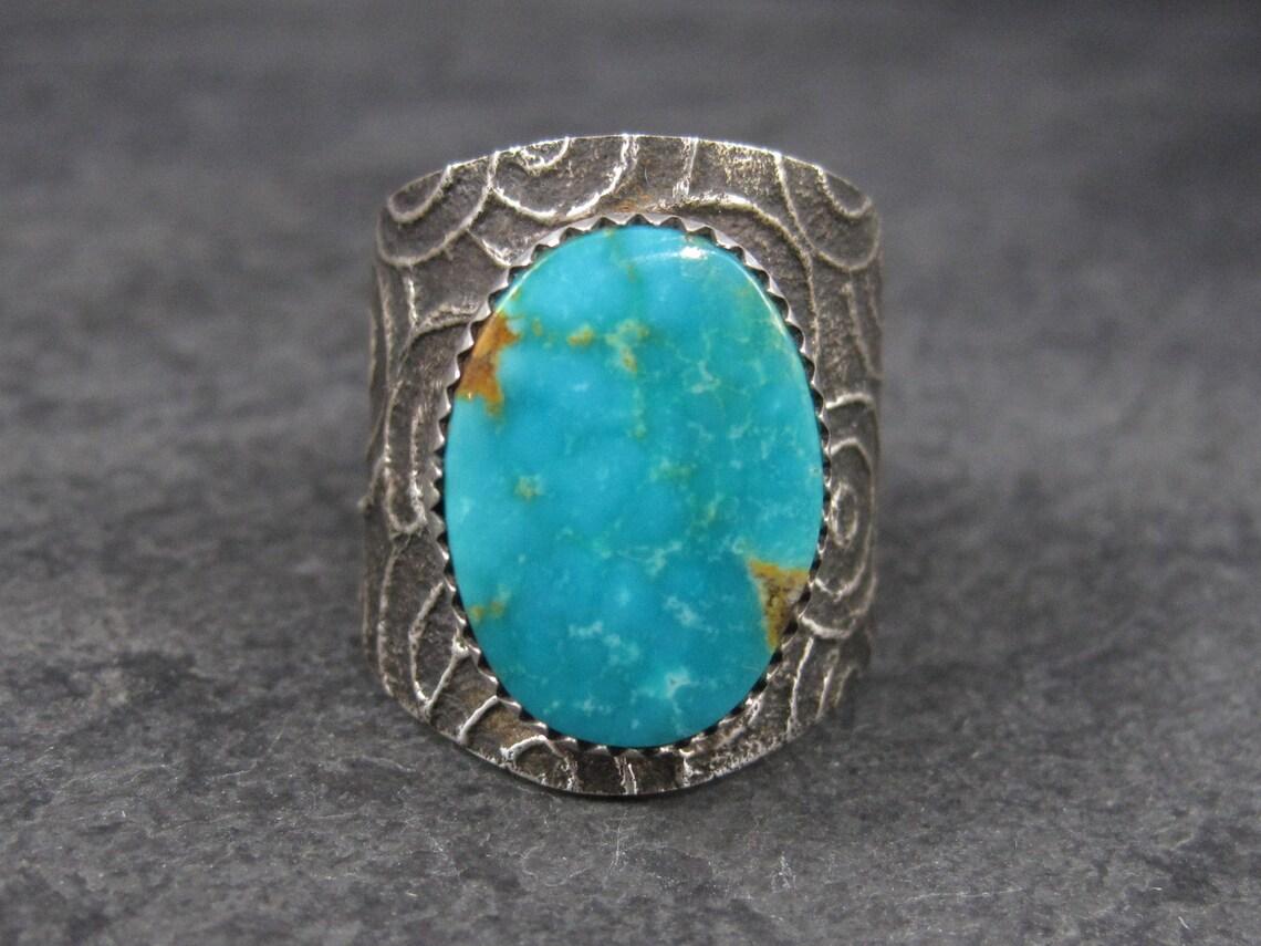 This gorgeous vintage ring is done in classic Tufa casting.
It features a 20x14mm natural turquoise.

The face of this ring measures 1 inch and tapers down to 3/8 of an inch.
Weight: 18.3 grams

Marks: Sterling

Condition: Excellent
*Note that where