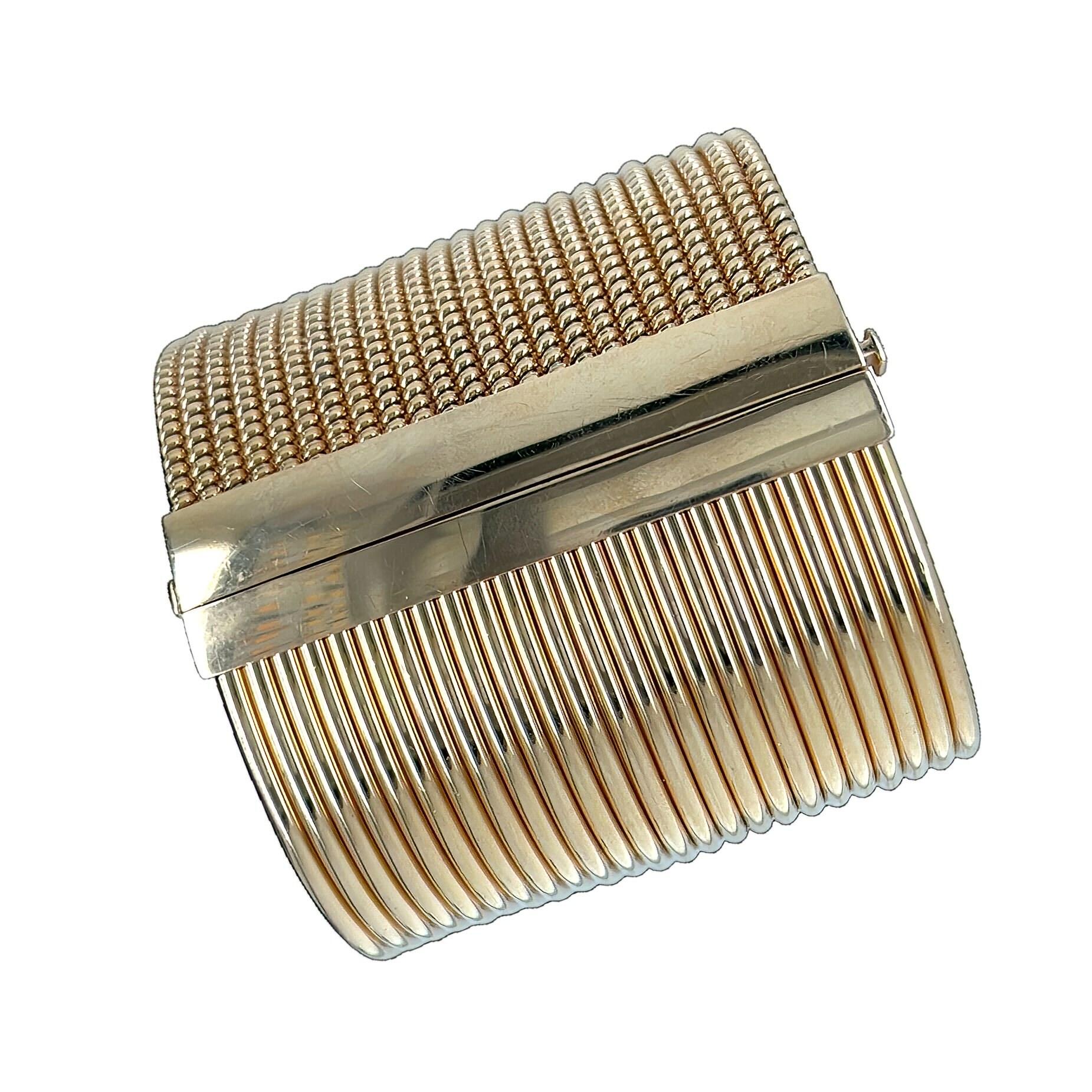 An 18 karat rose and white gold and diamond bracelet, Italian.  Designed as a cuff with one side of 24 rows of narrow rose gold tubogas, the other side of 24 rows of fluted, rigid rose gold, separated by bar of white gold pave set with approximately