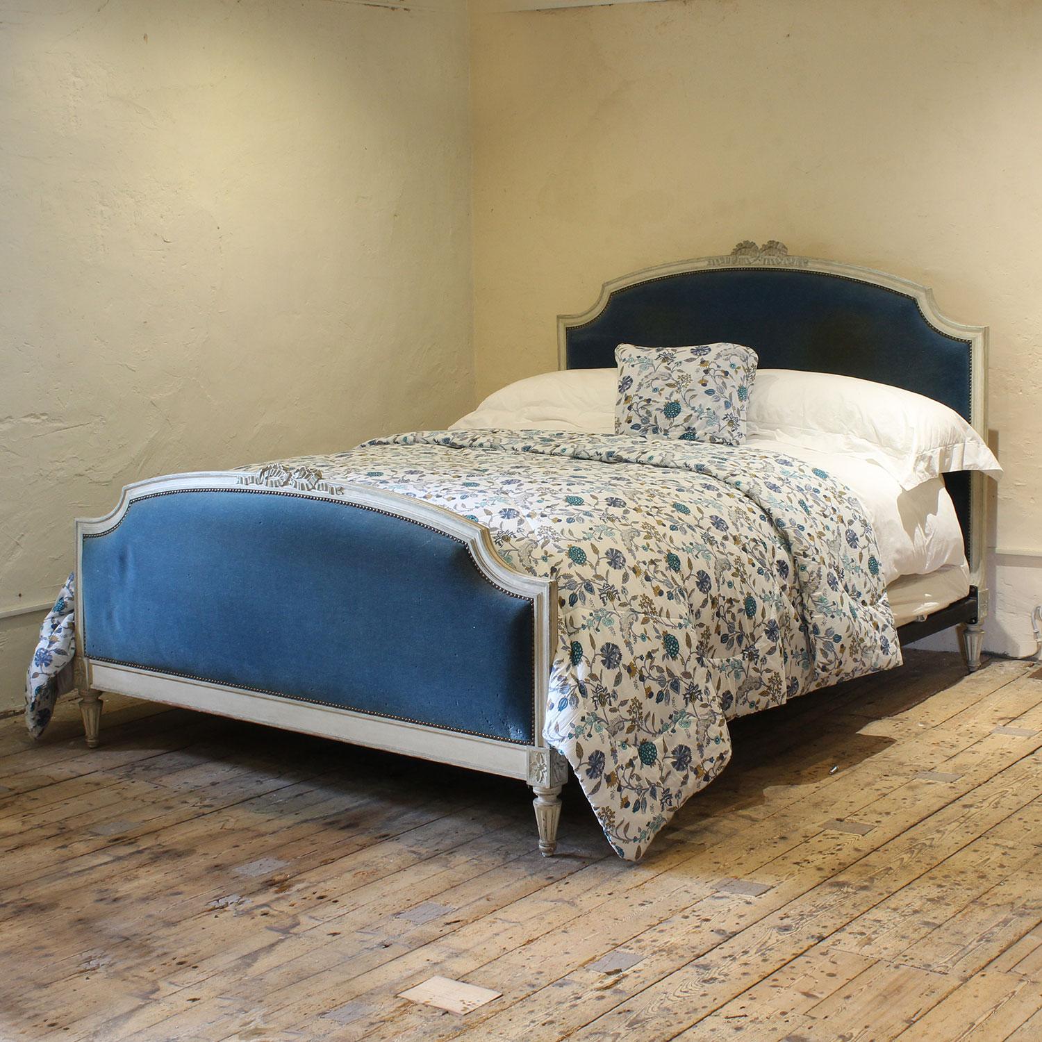 A wide French upholstered bed with white painted framework, simple elegant design and deicate carving. 
The blue velvet upholstery on this bed is in reasonable conidtion but really could do with replacing.
The price includes re-upholstery in a