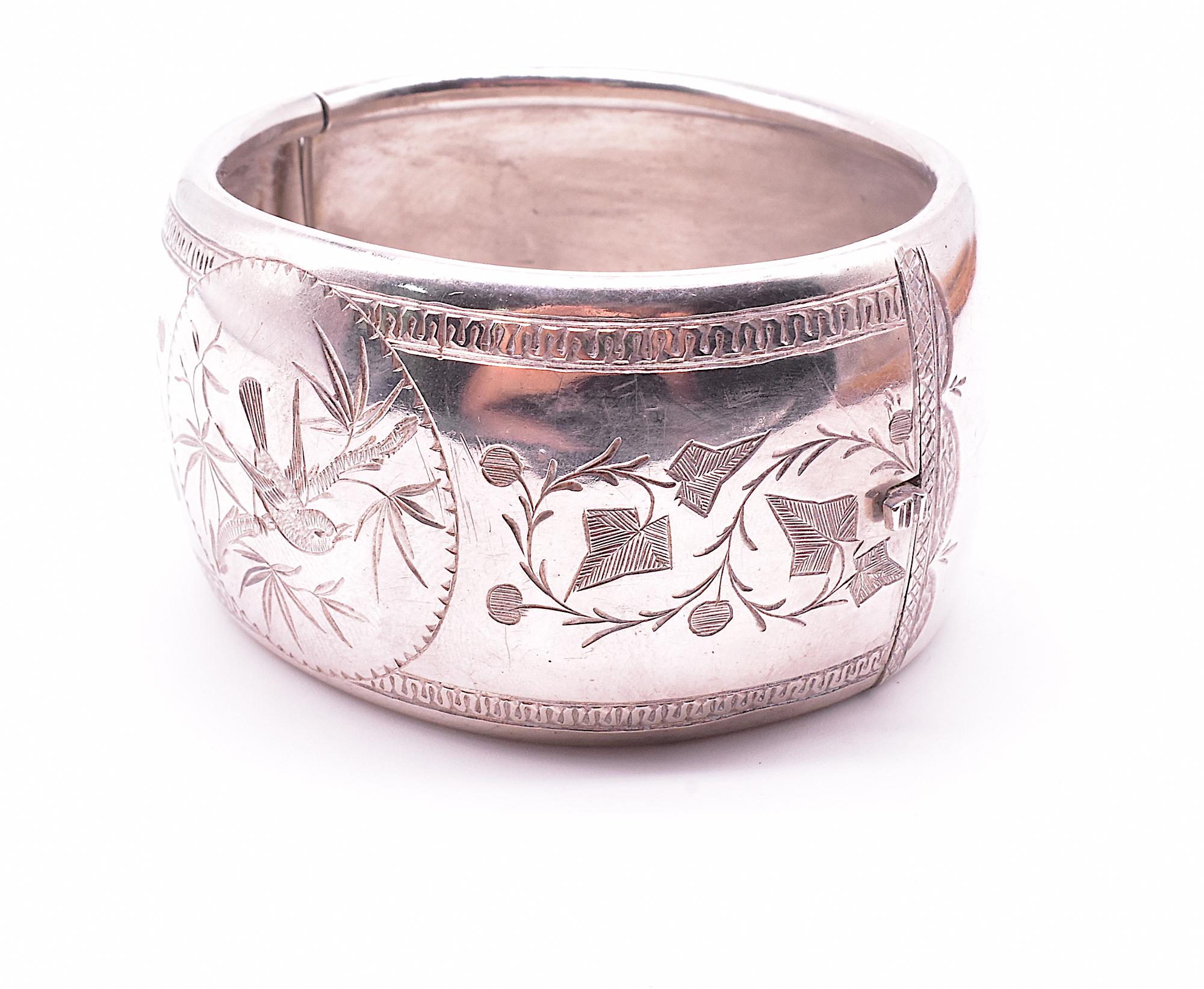 Substantial silver bangle bracelet with a stylized 