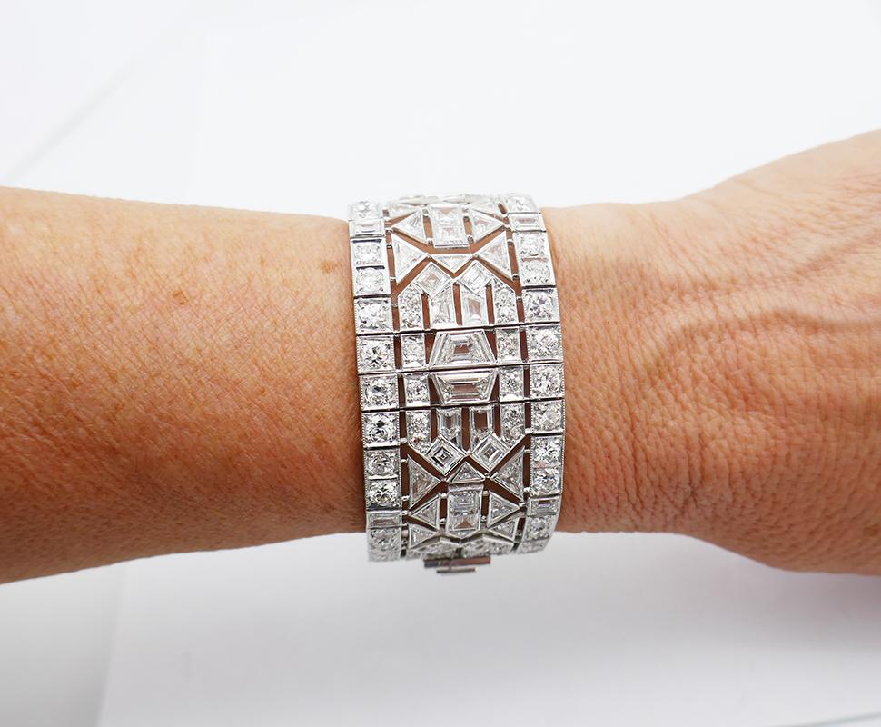        An exquisite wide vintage diamond platinum bracelet in Art Deco revival style. 
	The workmanship of this vintage bracelet is outstanding. There are multiple skillfully crafted moving parts. Each part carries a different pattern, and all