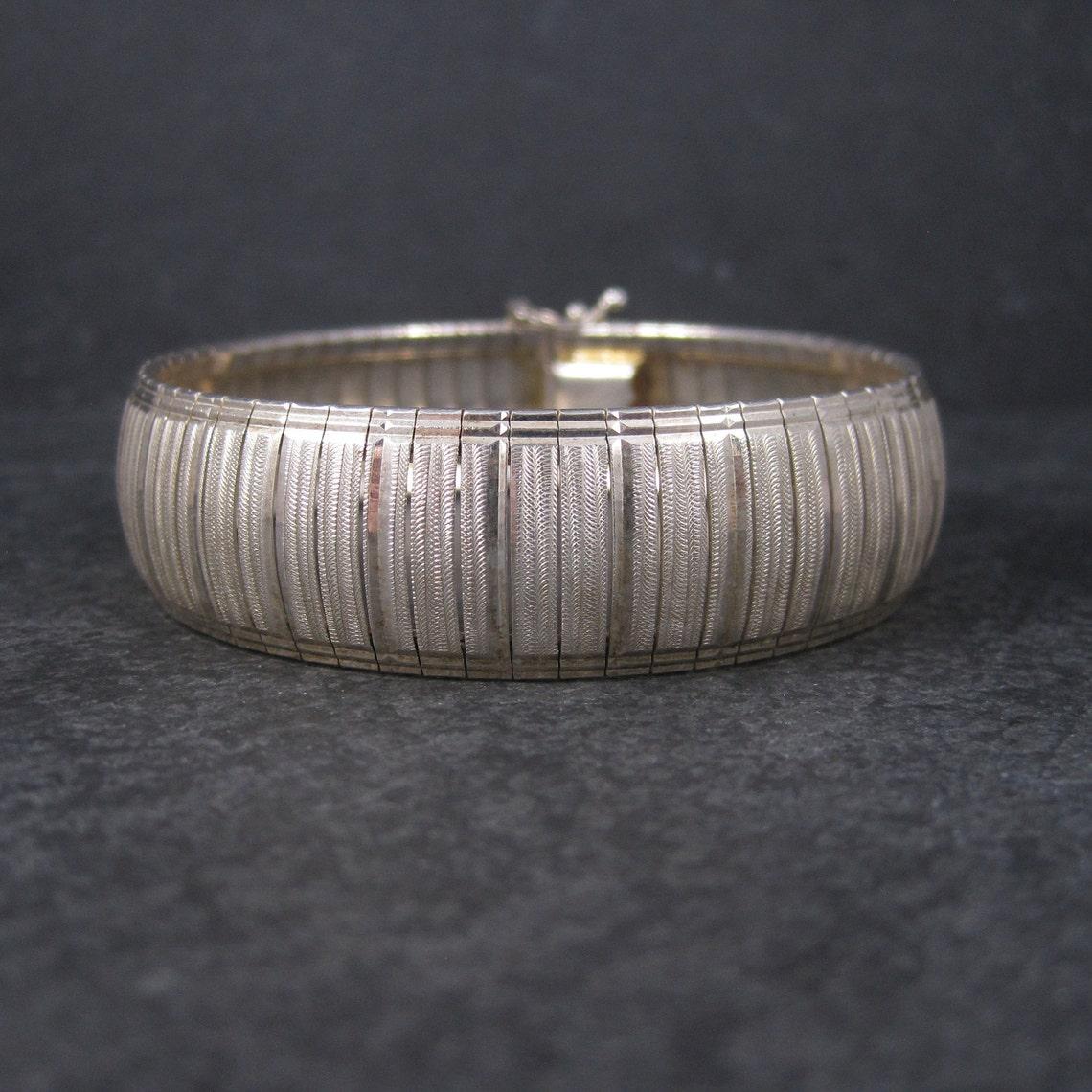 Questo splendido braccialetto anni '90 è in argento sterling 925.

Misura 18 mm di larghezza e 7,5 pollici di lunghezza.

Marchi: 925

Condit: Lucidato e pronto per essere indossato.