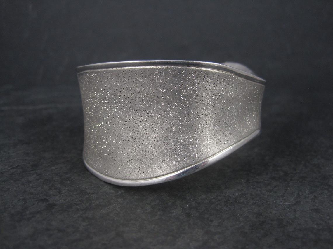 This beautiful sterling cuff bracelet is the creation of French designer Charles Garnier.
It features a wave design and the famous sparkling texture which has become iconic for Garnier pieces.

At its widest point, this cuff measures 1 5/16 inches
