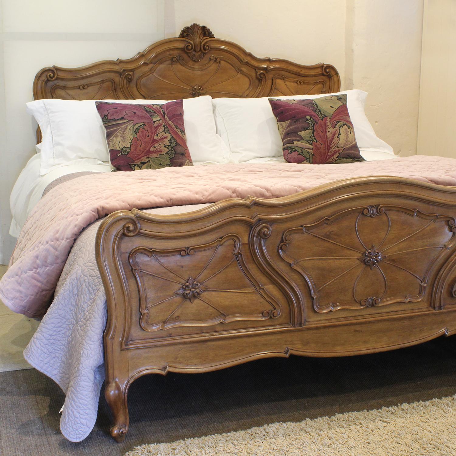 A superb and rare Italian Louis XV style wooden bedstead in walnut with elegantly shaped design and decorative pediment. Circa 1920.

A firm bed base is included in the price. 

The mattress, bedding, bed linen and throws all all extra and can