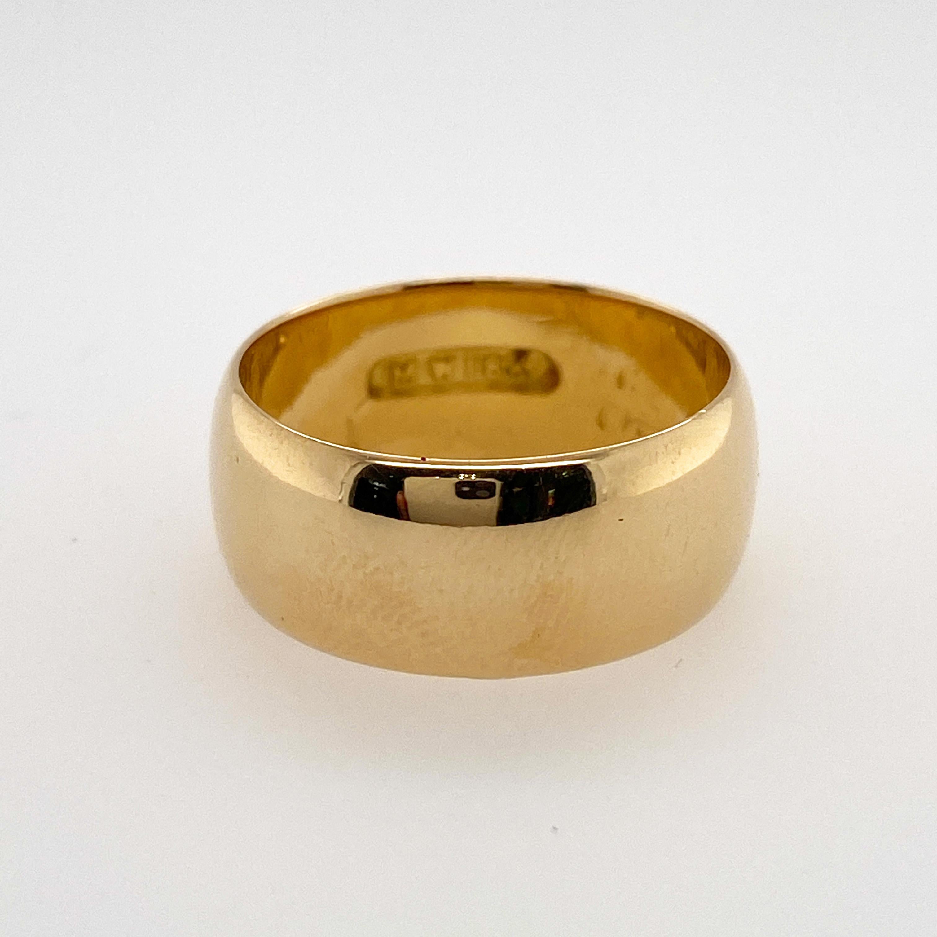 This classic domed wedding band is made in a bold 8.5 millimeter width, with the warm color that comes from brightly polished 18 karat yellow gold. The profile of the band is made in a low dome that makes it extremely comfortable to wear. The