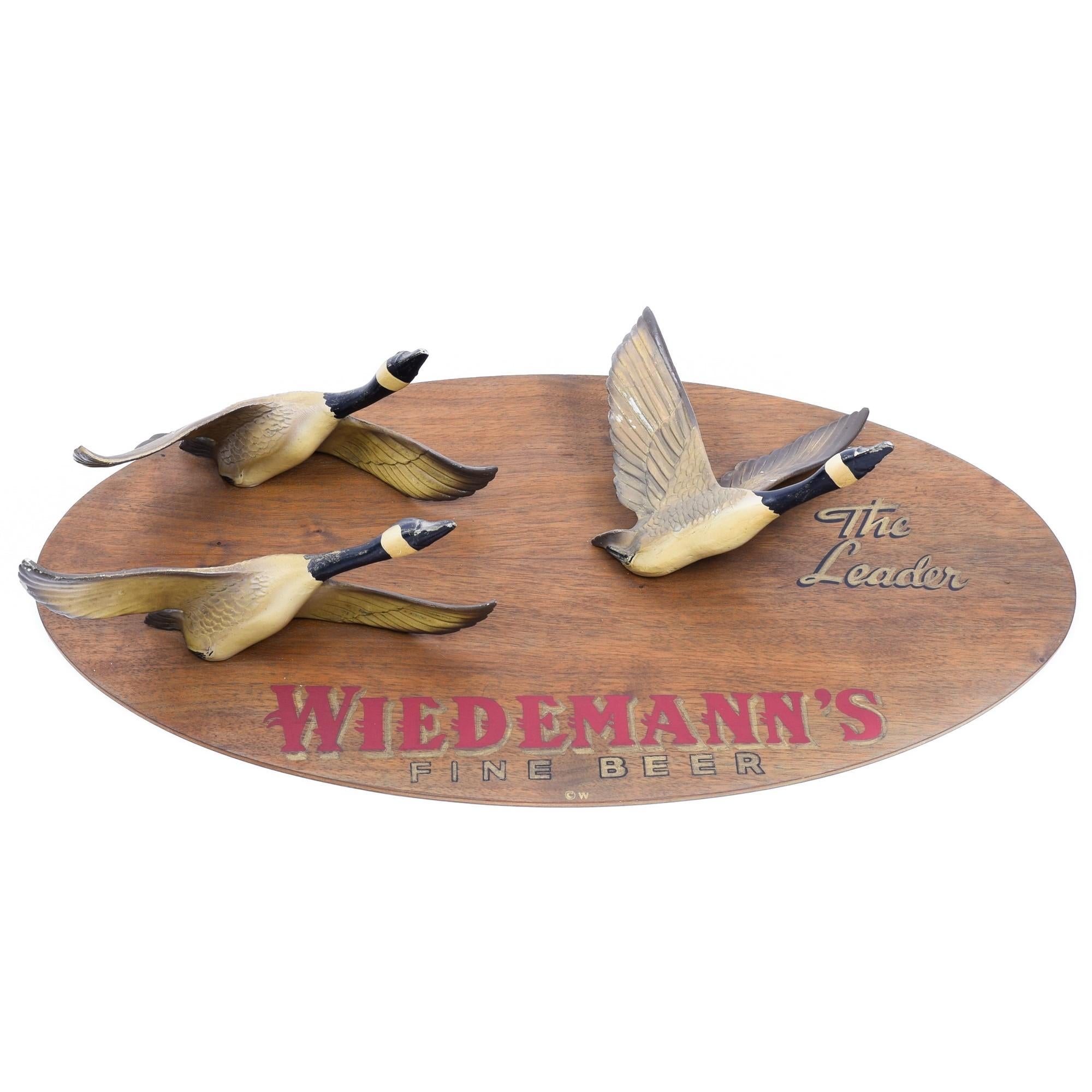 Wiedemann's Fine beer - The Leader Trade sign with three Canada geese on oval walnut plaque. 

German immigrant George Wiedemann began brewing at the original Wiedemann brewery in Newport, Kentucky in 1870. Today, 150 years later, we remain