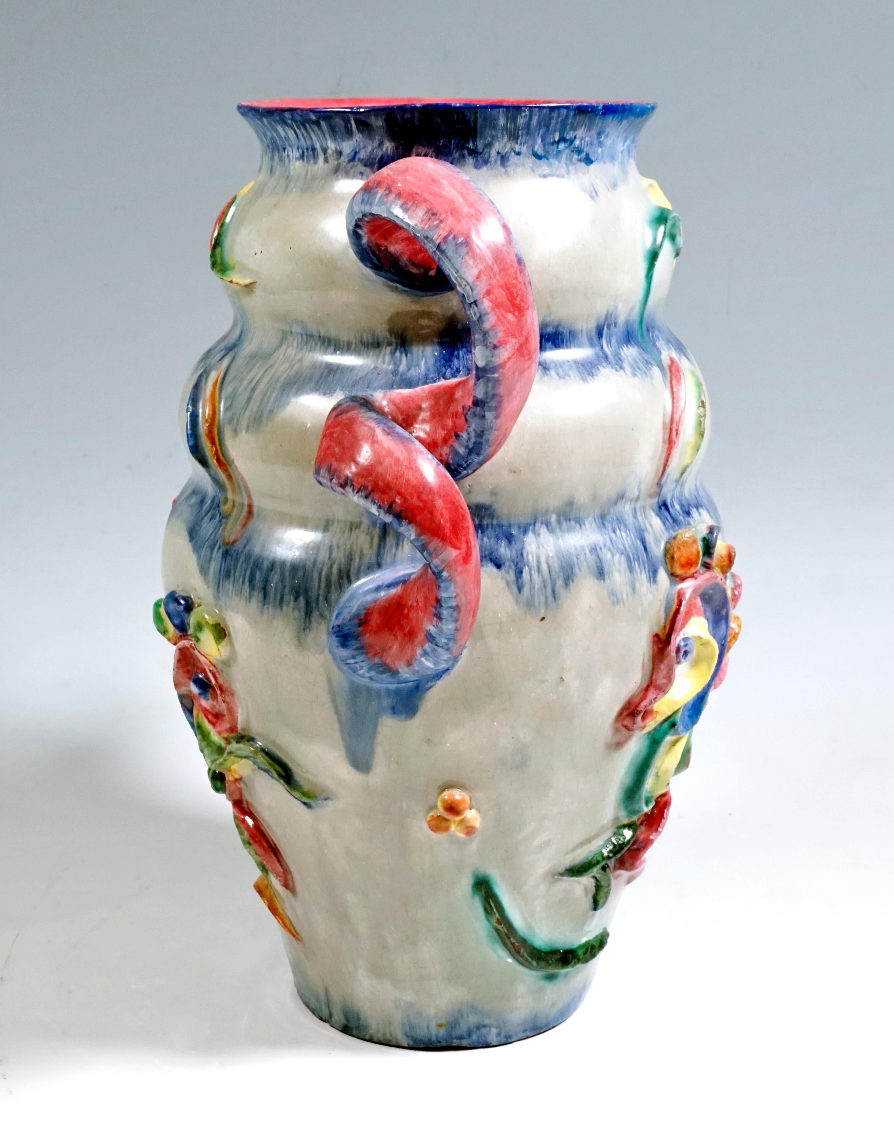Bulbous vase on a round floor plan, two bulging rings that narrow towards the top with a flared rim of the mouth, surface decorated in relief with abstract, brightly painted elements, two spiral-shaped handles attached opposite one