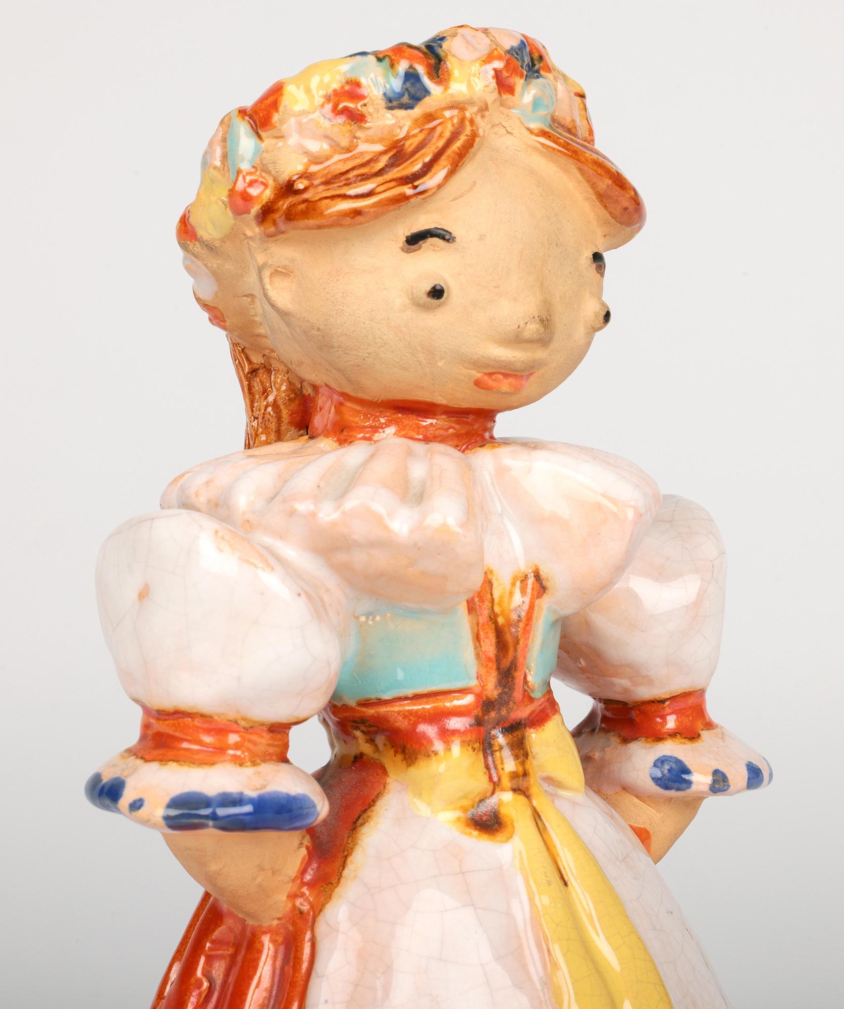 A very stylish Art Deco pottery painted figure of a girl in the style of Wiener Werkstatte, Austria and possibly Michael Powolny, dating from around 1930. The girl is hand crafted from a light terracotta style clay and is modelled as a young girl
