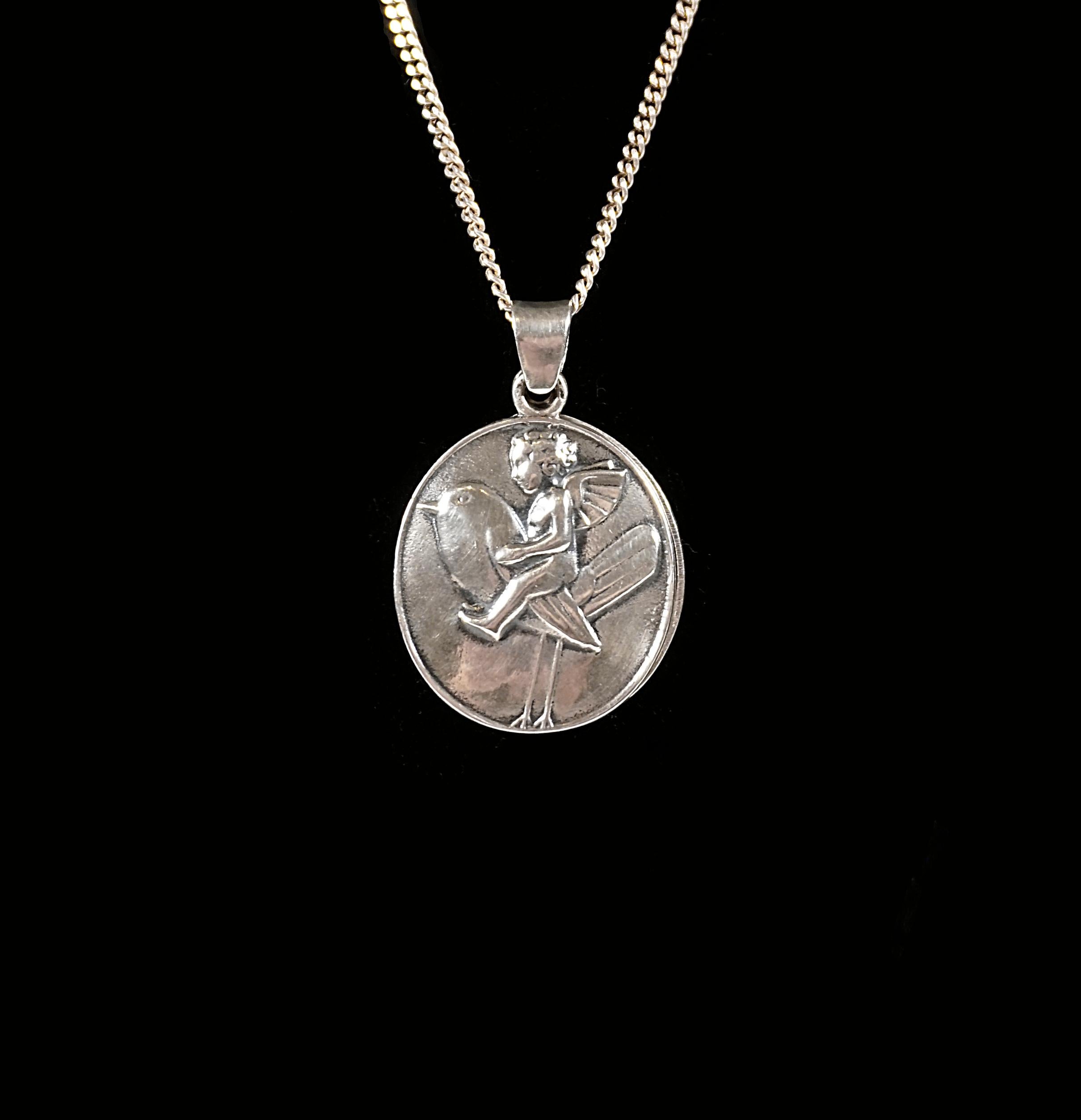 Pendant with embossed motif: Cupid sitting on a bird made of alpaca, silver-plated, two movable medallions, designer's monogram marked on the reverse: Bertold Löffler (Rosenthal 1874 - 1960 Vienna), mark of the Wiener Werstätte and part of the rose
