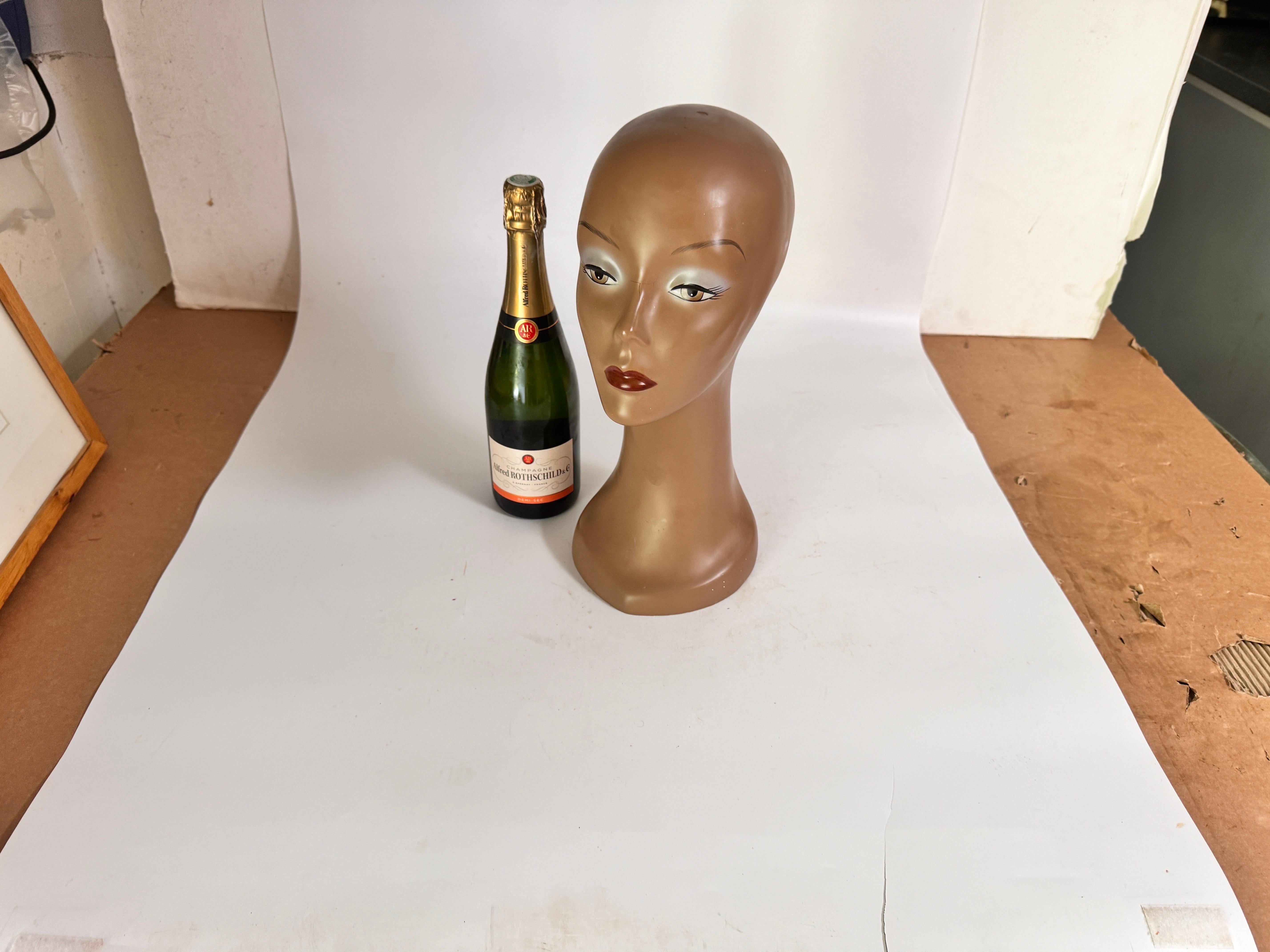 Cette sculpture est un porte-perruque, réalisé dans les années 1970 en France. Il s'agit d'une tête de femme, de couleur marron.