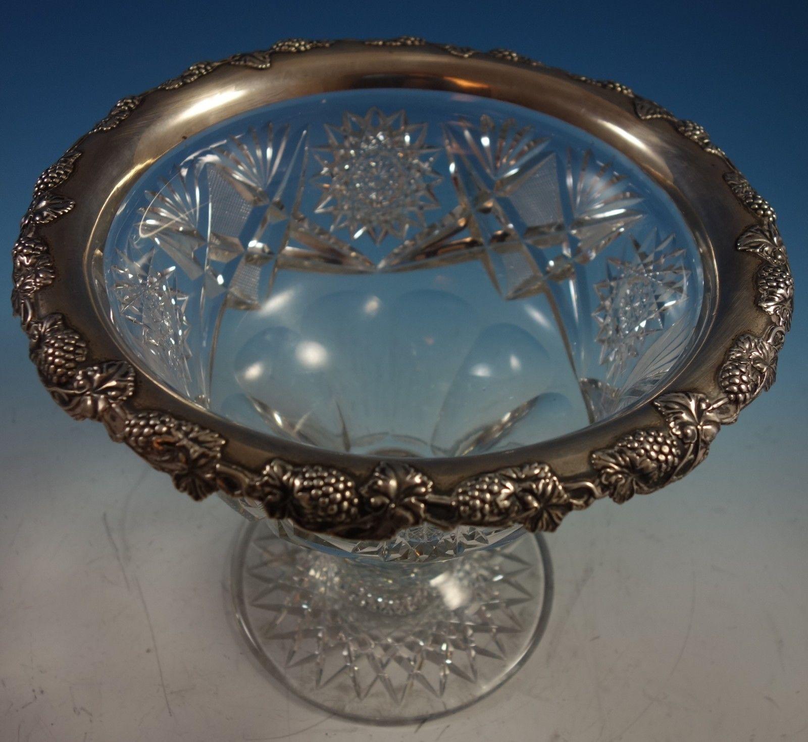 Impressive Wilcox Co. punch bowl made of cut glass with a sterling silver rim that features grapes and grape leaves. The bowl measures 8 1/2