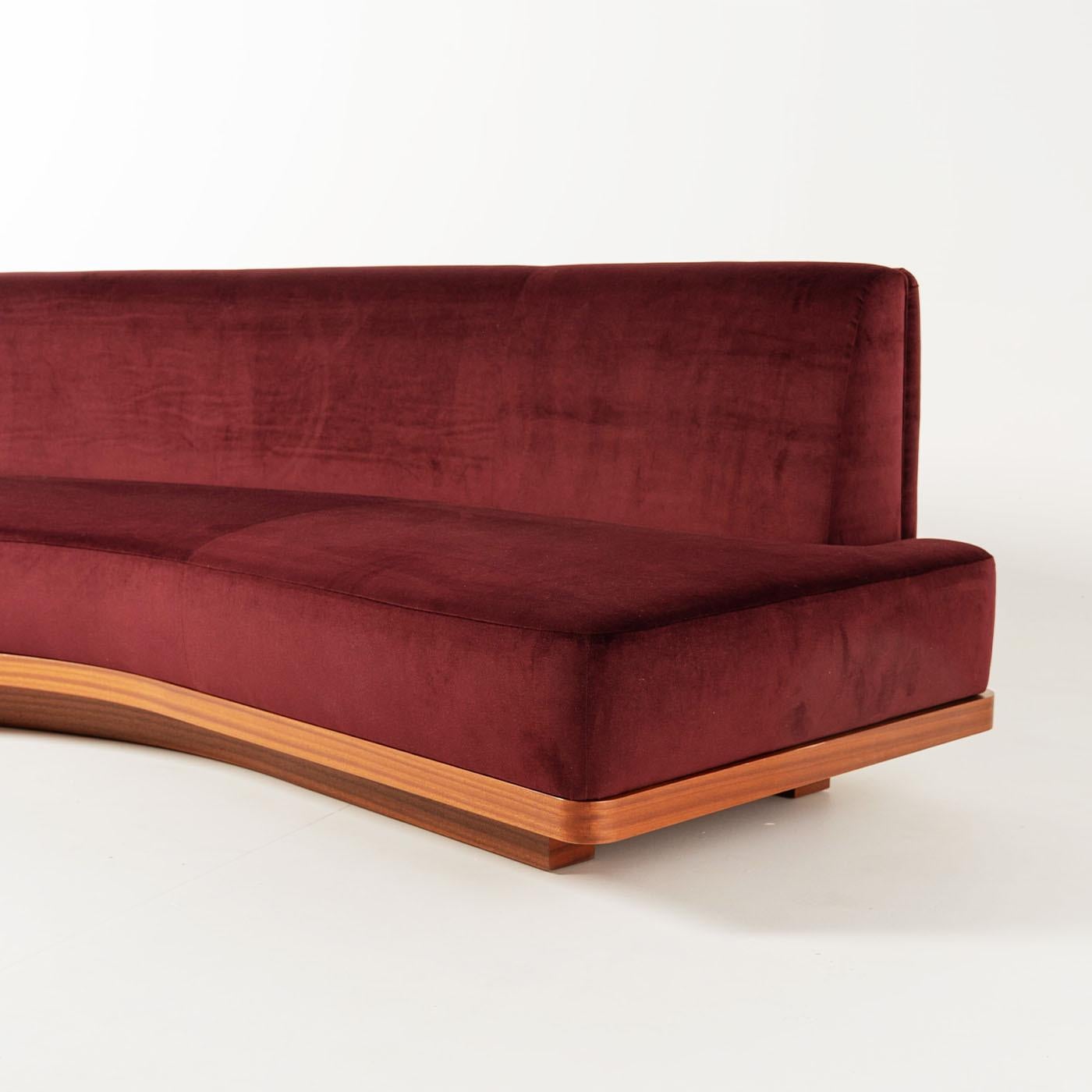 Dieses mittelgroße Sofa von Lorenza Bozzoli zeichnet sich durch seine geschwungene Silhouette aus, die mit weinrotem Samt gepolstert ist und modernen Stil mit Komfort verbindet. An der Rückseite ist ein Mahagonischrank mit zwei Türen angebracht, der
