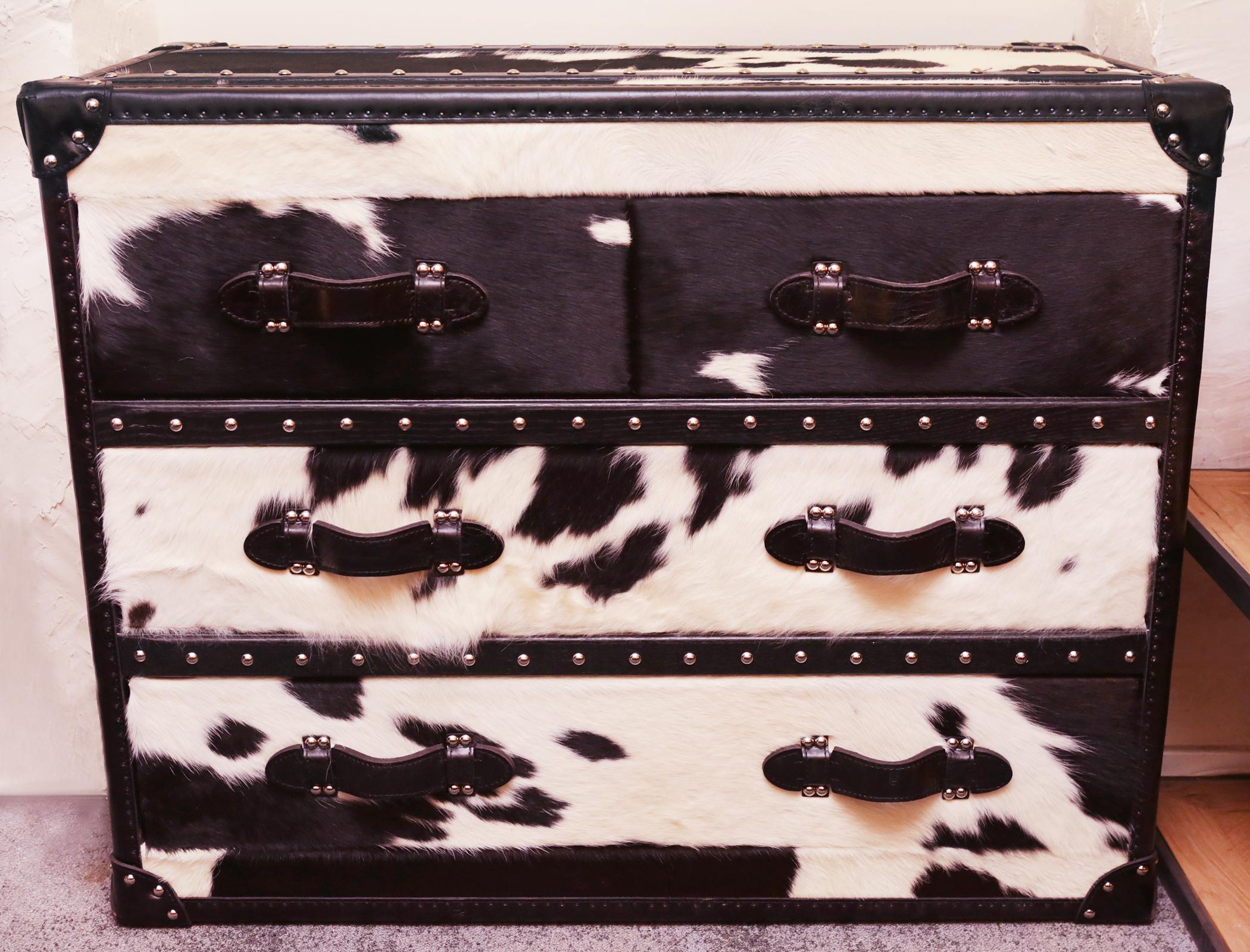 Wild black and white cowhide medium high chest
with structure in solid wood and covered with 
natural black and white cowhide. With black
genuine leather handles and with polished 
stainless steel nails. With 4 drawers with black 
fabric inside.