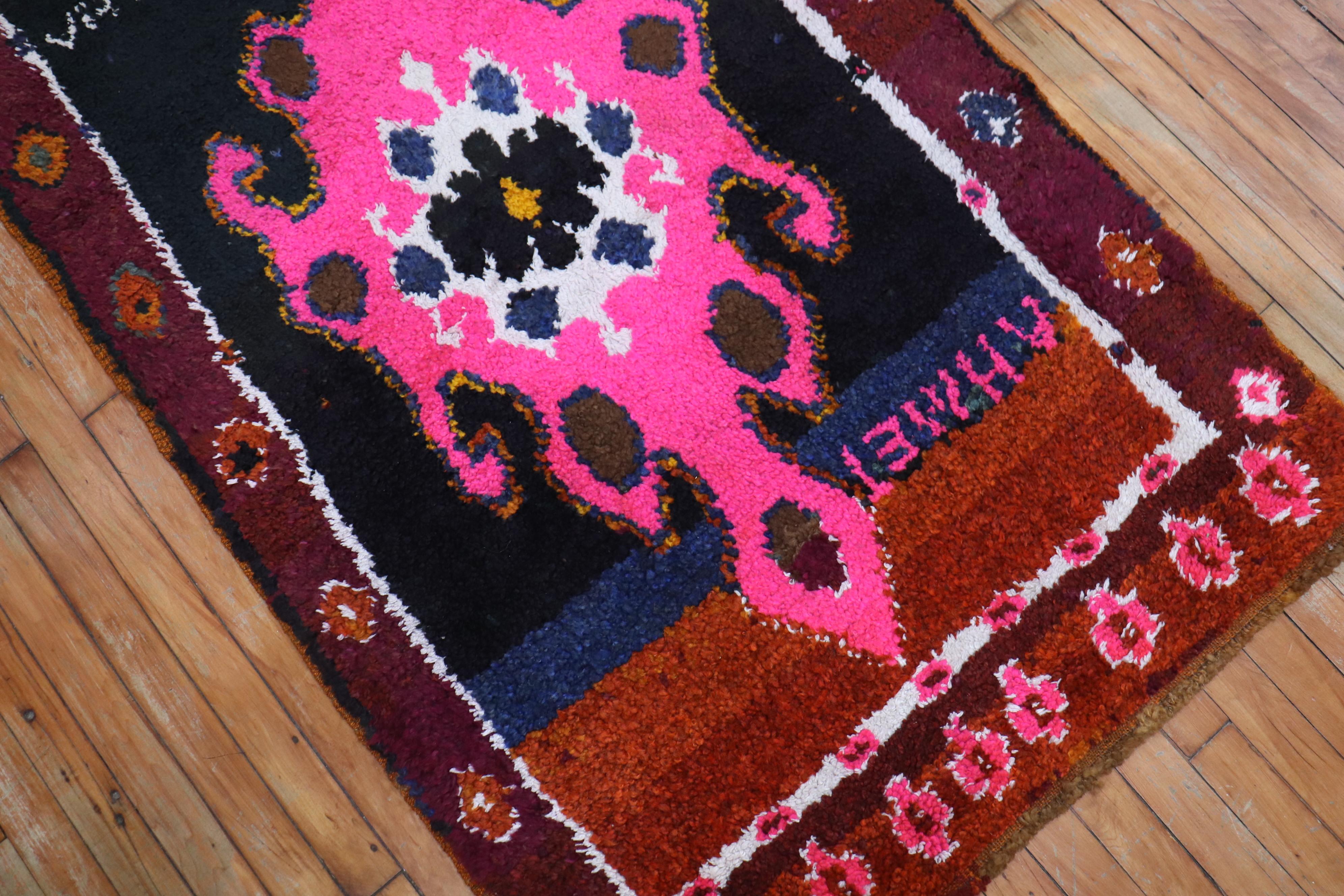 A long wool pile Turkish runner with saturated colors featuring an intense pink color we seldom find in vintage rugs. This piece must have been custom ordered due to the wild colors and it 2 Turkish names inscribed within the field

Measures: 3'3”