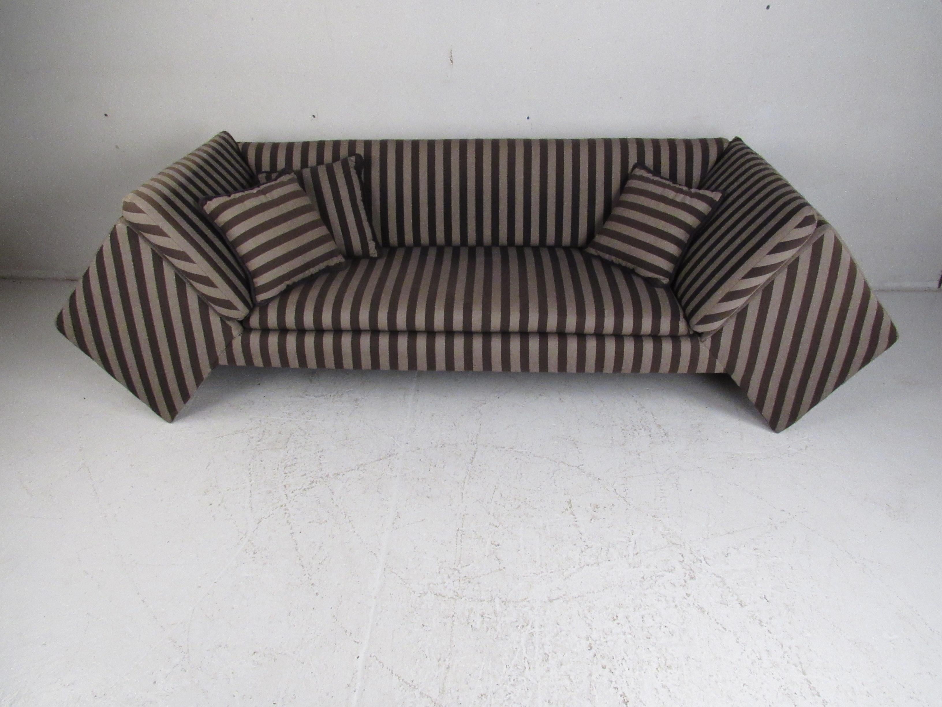 This stunning contemporary modern sofa boasts unusual diamond shaped sides, overstuffed cushions, and an elegant striped upholstery. An amazing piece with high armrests that angle outward and a bridge style design ensuring maximum comfort. A well