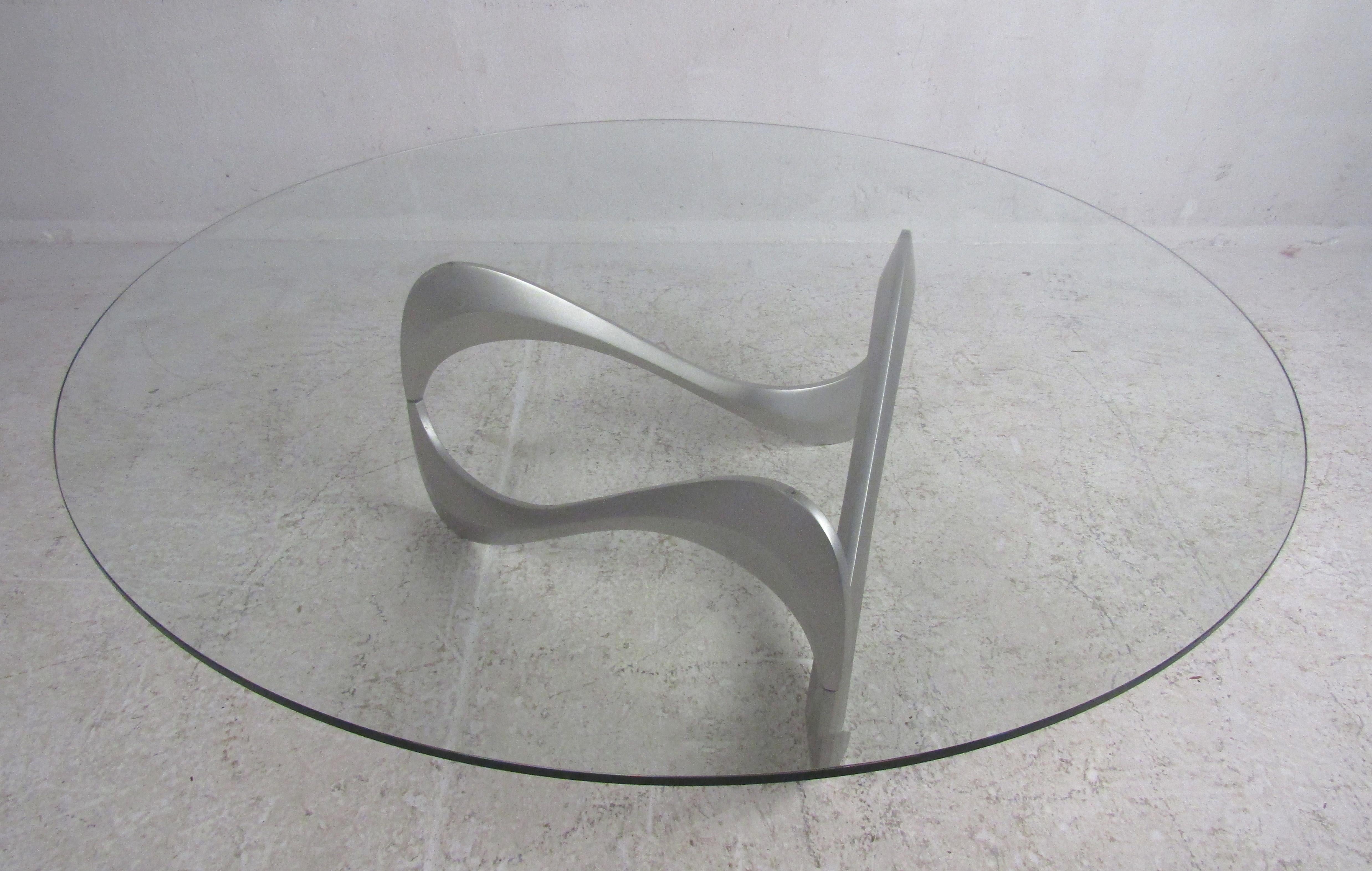 This amazing vintage modern coffee table boasts a thick circular glass top with beveled edges. Sleek design with a scribble shaped, sculped metal base. This lovely table makes the perfect addition to any home, business, or office. Please confirm the