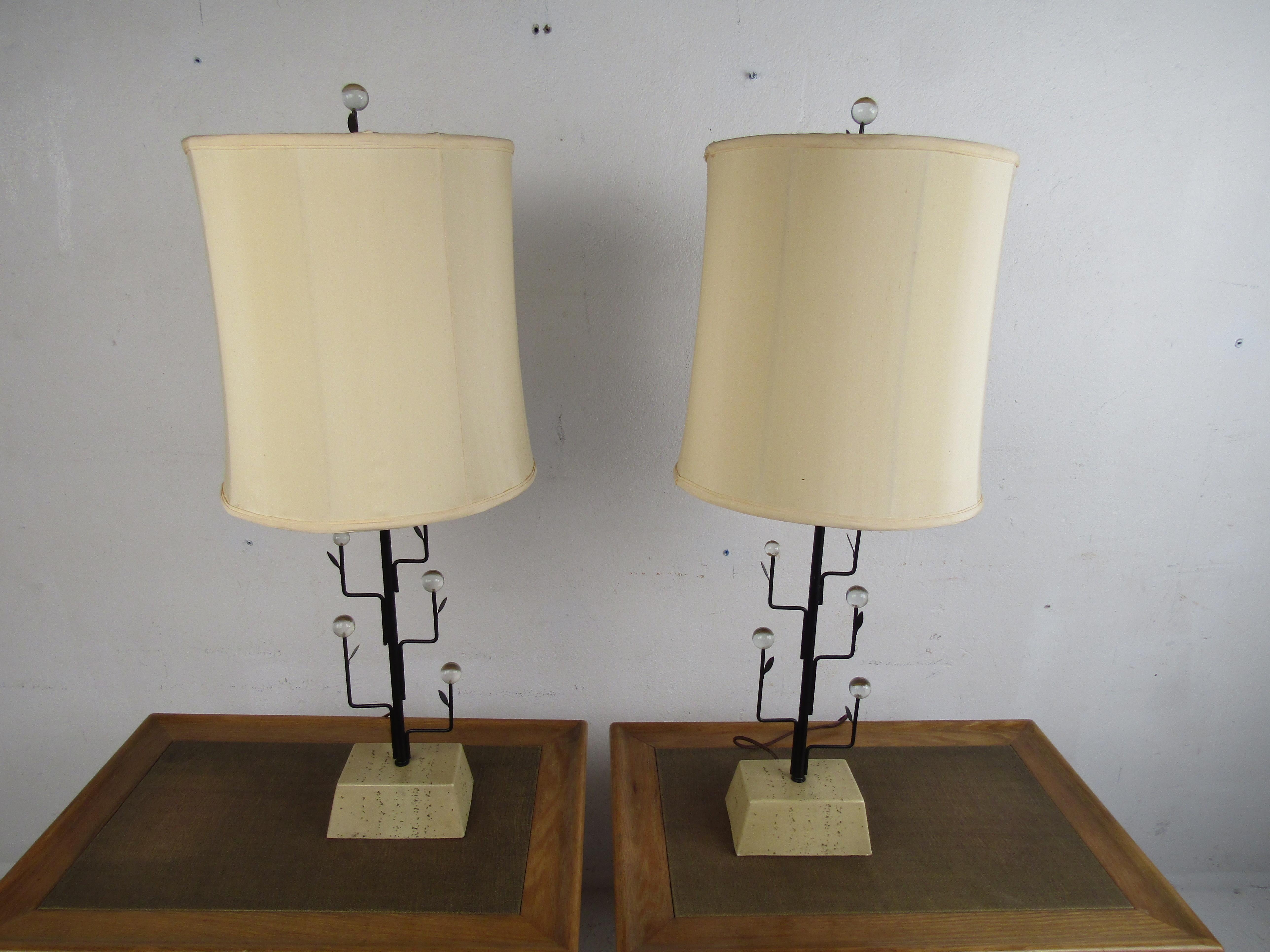 This stunning pair of vintage modern lamps stand out from the rest. An unusual porous, trapezoid-shaped, stone base supports this slightly tall table lamp. A lovely metal tree branch and leaves design with Lucite balls resting on the tops