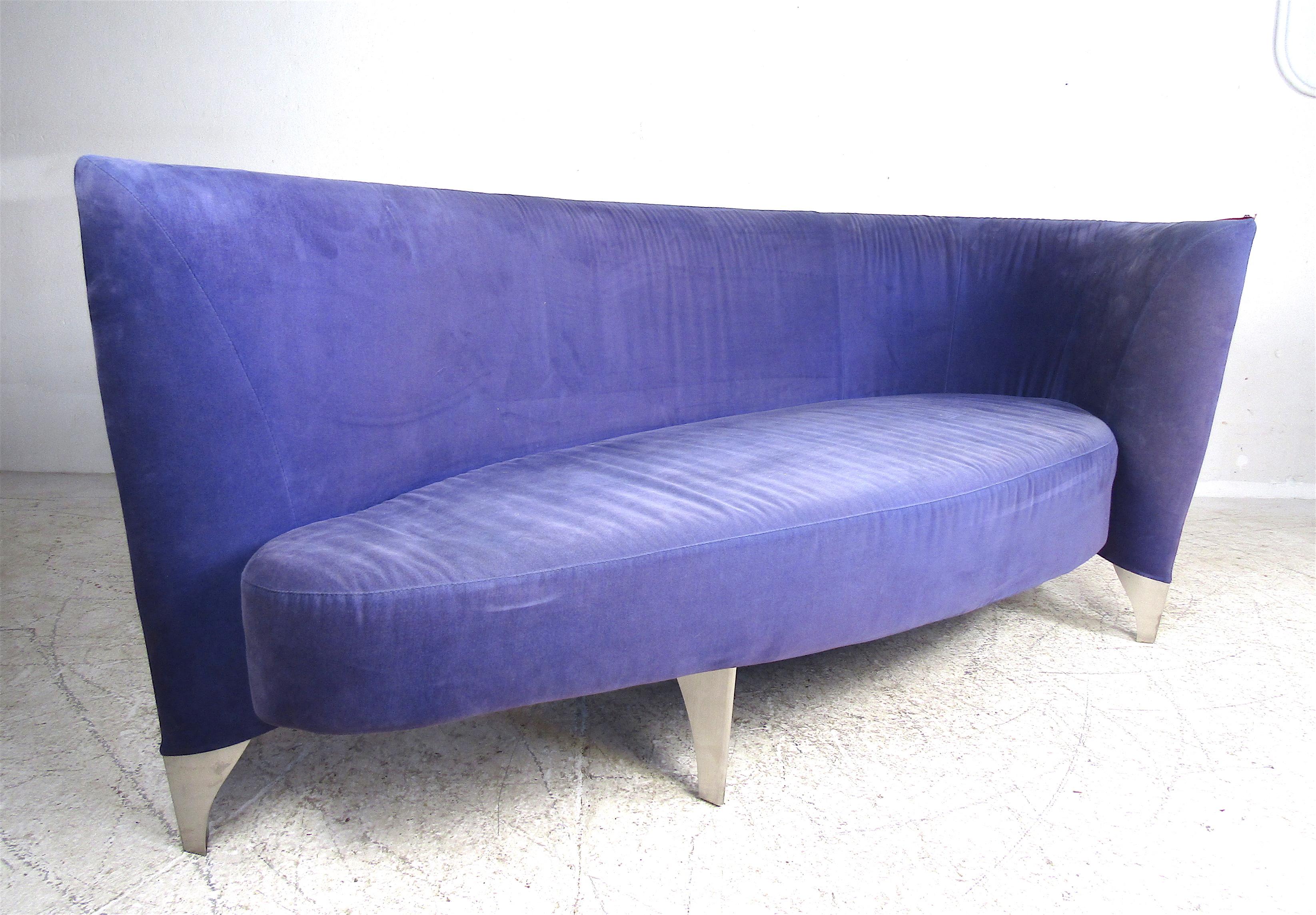 This beautiful two-tone sofa features an unusual wraparound armrest on one side. This funky piece can function as a daybed or a sofa for the living room. The wonderful blue and red velvet fabric complement the silver metal legs. A stylish and sturdy