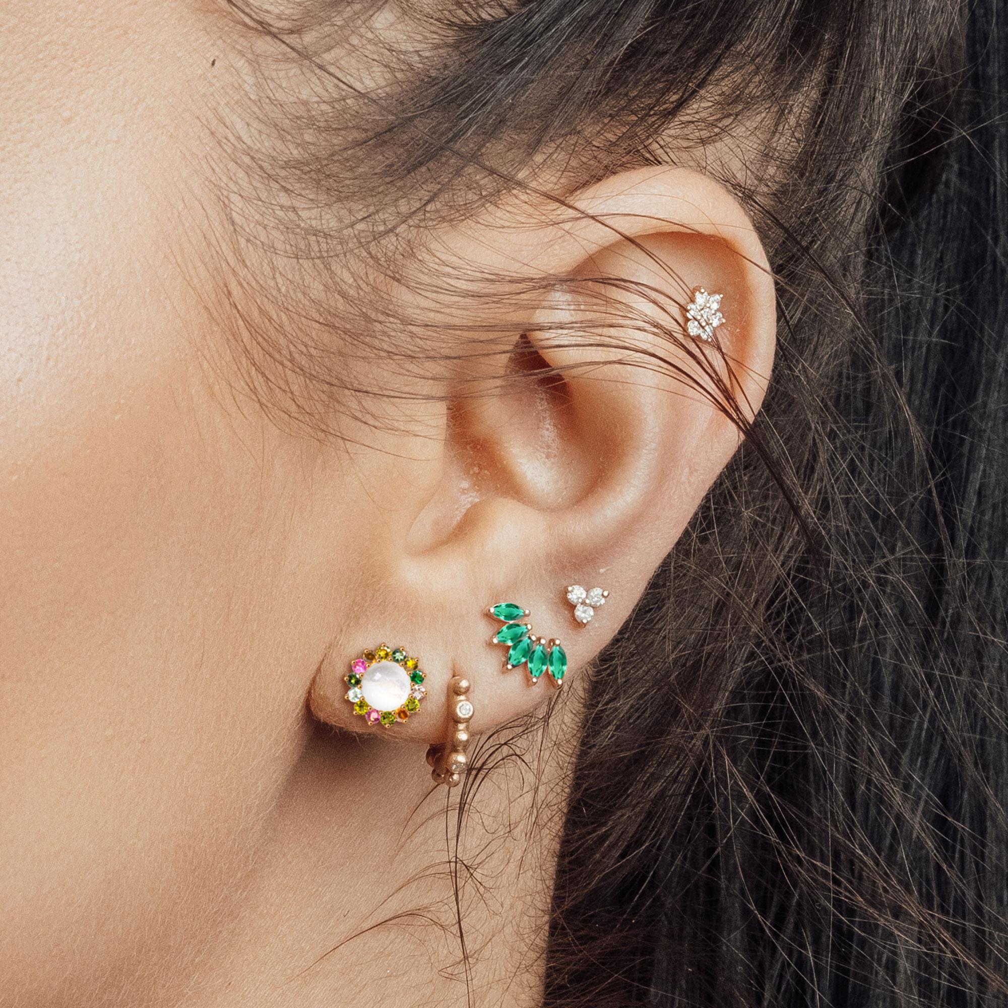 Inspired by the gorgeous leaves of nature and reimagined into a little piece of artistry! This pretty 18k Emerald Gold Stud earrings design features five marquise-shaped stones beautifully prong set in a half-circle wreath. Finely crafted in a