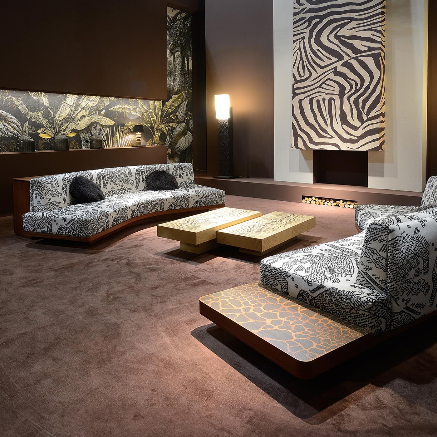 Ein elegantes und multifunktionales Design von zeitloser Raffinesse. Dieses Sofa zeichnet sich durch eine seitliche Tischplatte aus, die mit einer Intarsienarbeit aus Giraffenstreifen auf der Mahagonisperrholzstruktur verziert ist. Er ist mit einem