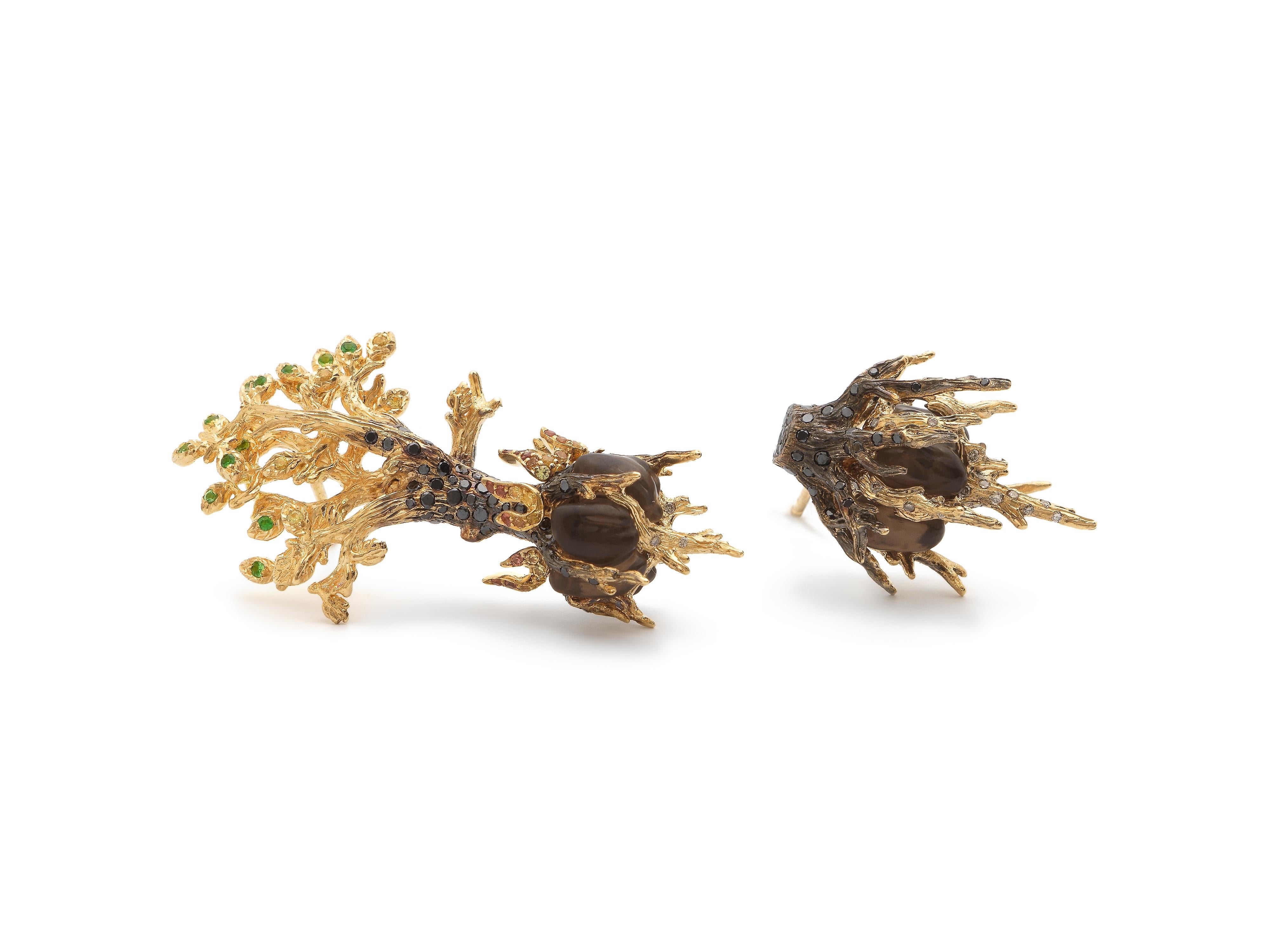 These intricately detailed, asymmetric earrings – one to represent a tree’s branches and the other its roots - are symbolic of the destruction of nature but also its rebirth. The earrings are designed in 18k yellow gold, lent a smoky look with black