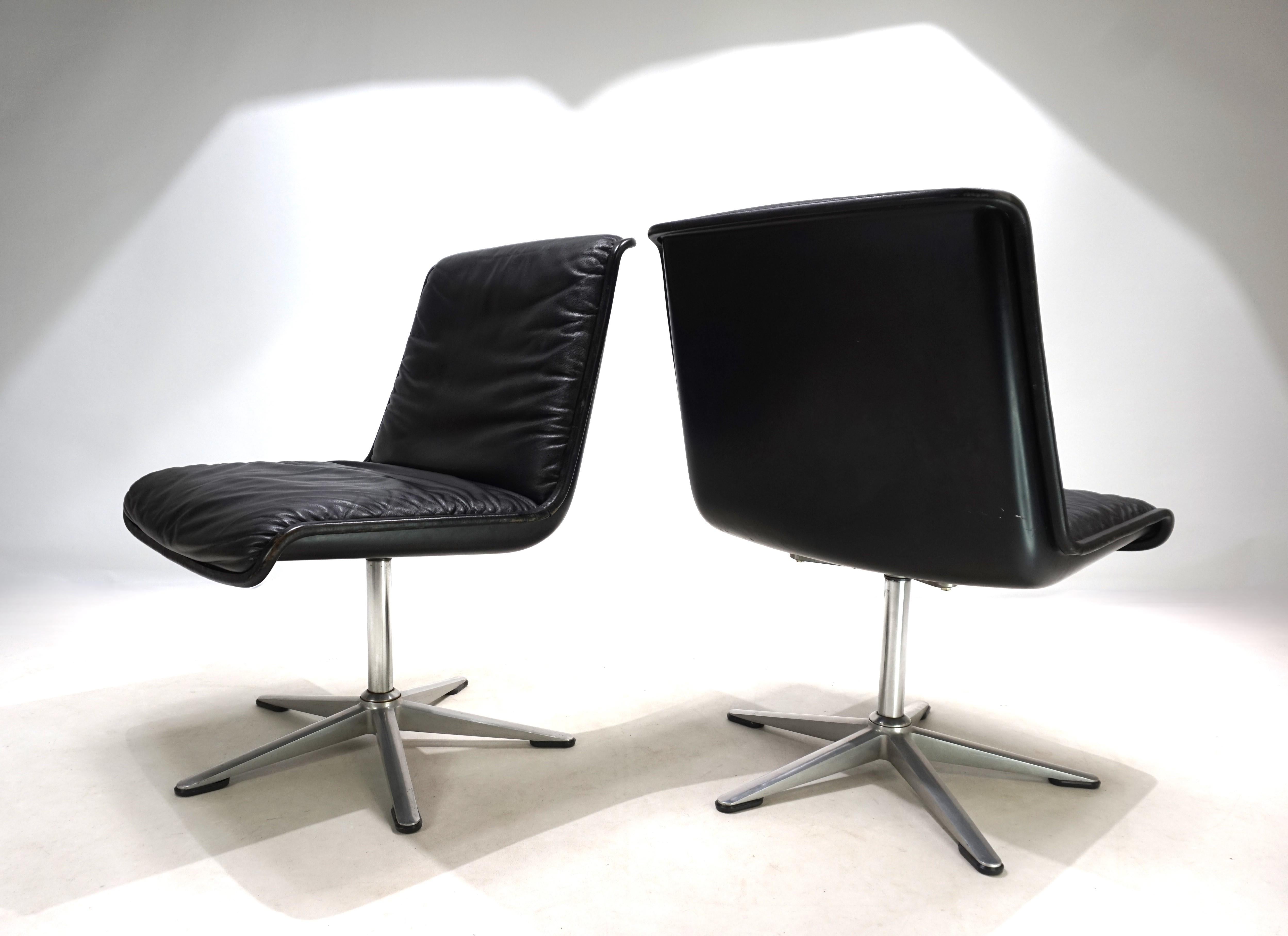 This set of two Wilkhahn Delta 2000 chairs, in a deep black leather, brushed aluminum, and with black shells, is in excellent condition. The leather of the chairs shows hardly any signs of wear, and the piping displays minimal patina. The swivel